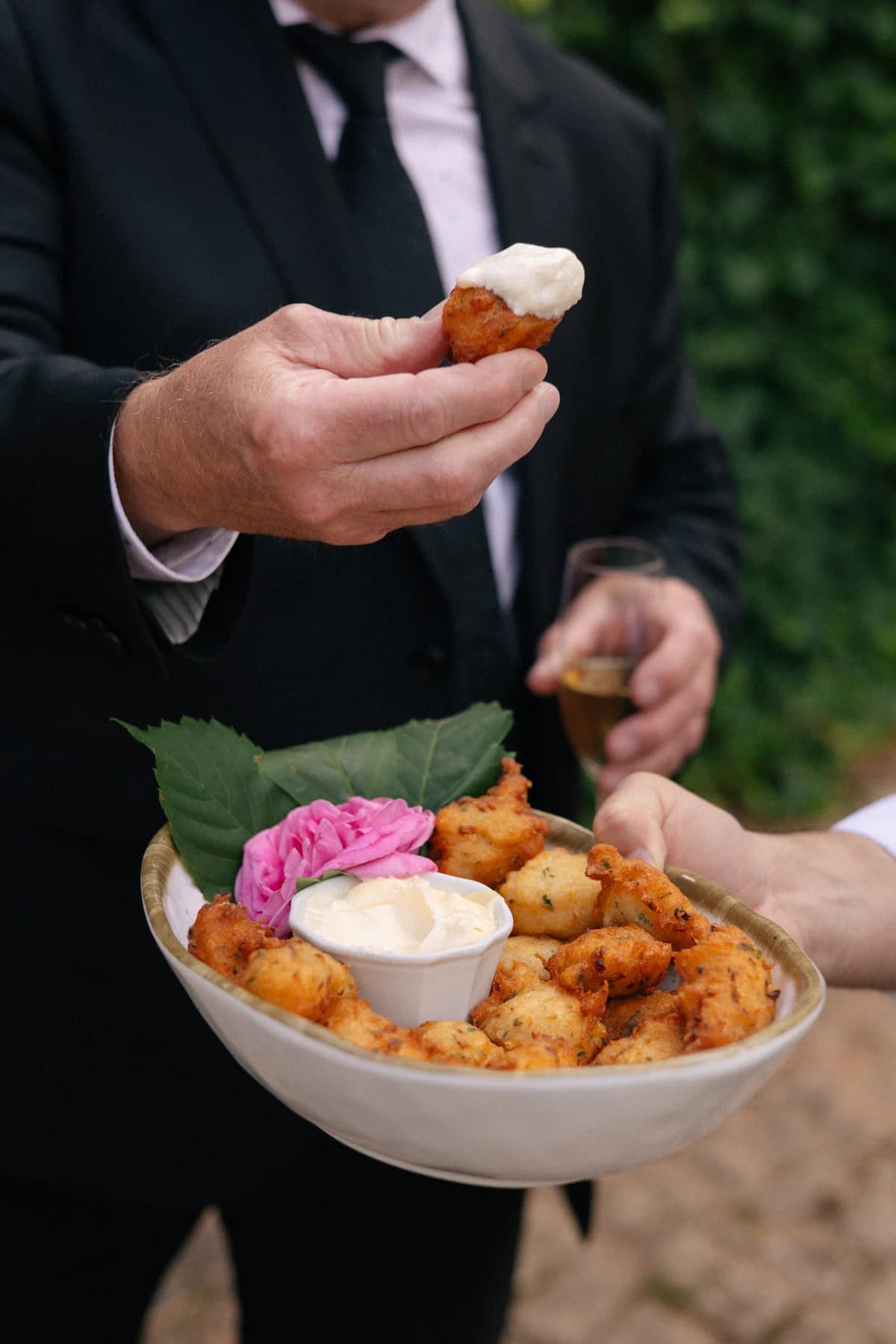A guest enjoying a canapé from a serving bowl