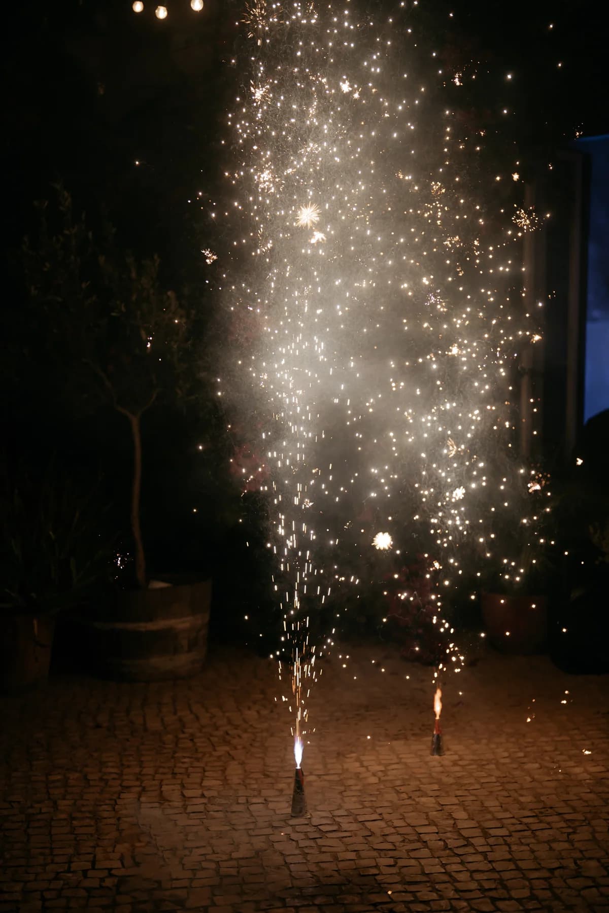A sparkler fountain lighting the courtyard at night
