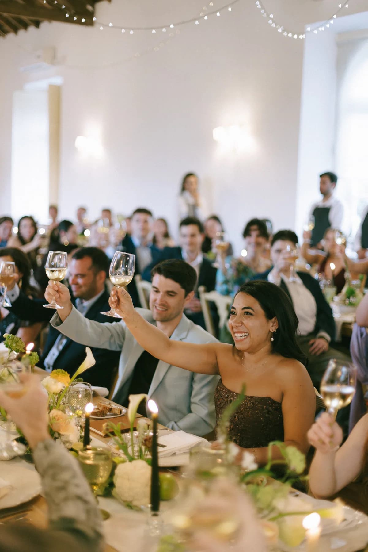 Guests smiling and applauding during the wedding dinner