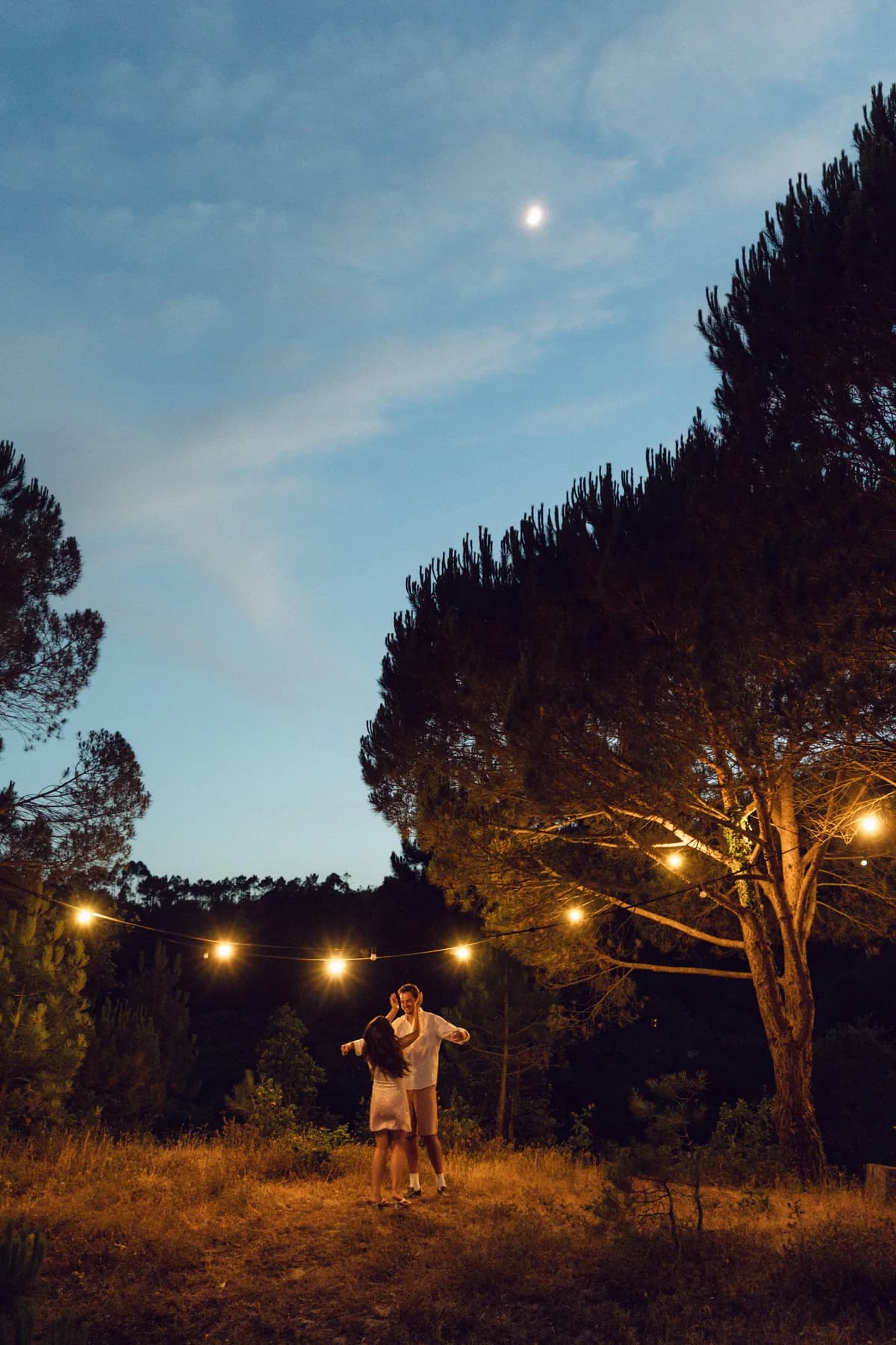Guests beneath string lights at the evening welcome party