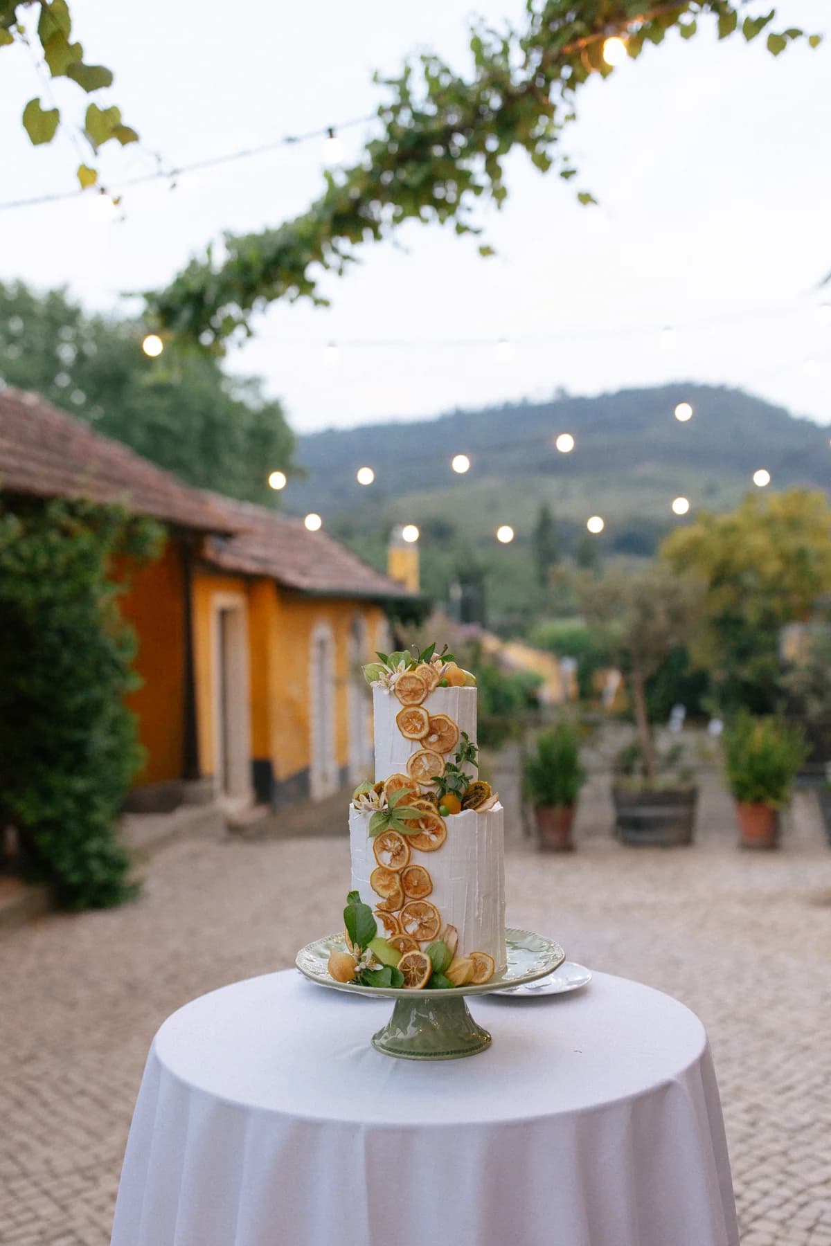 A tiered cake on a round table in the courtyard