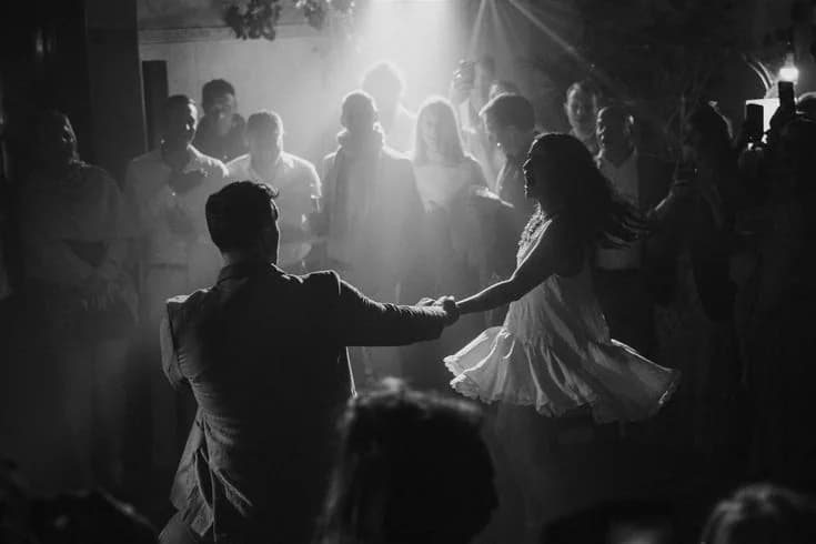 A couple dancing among guests in black and white