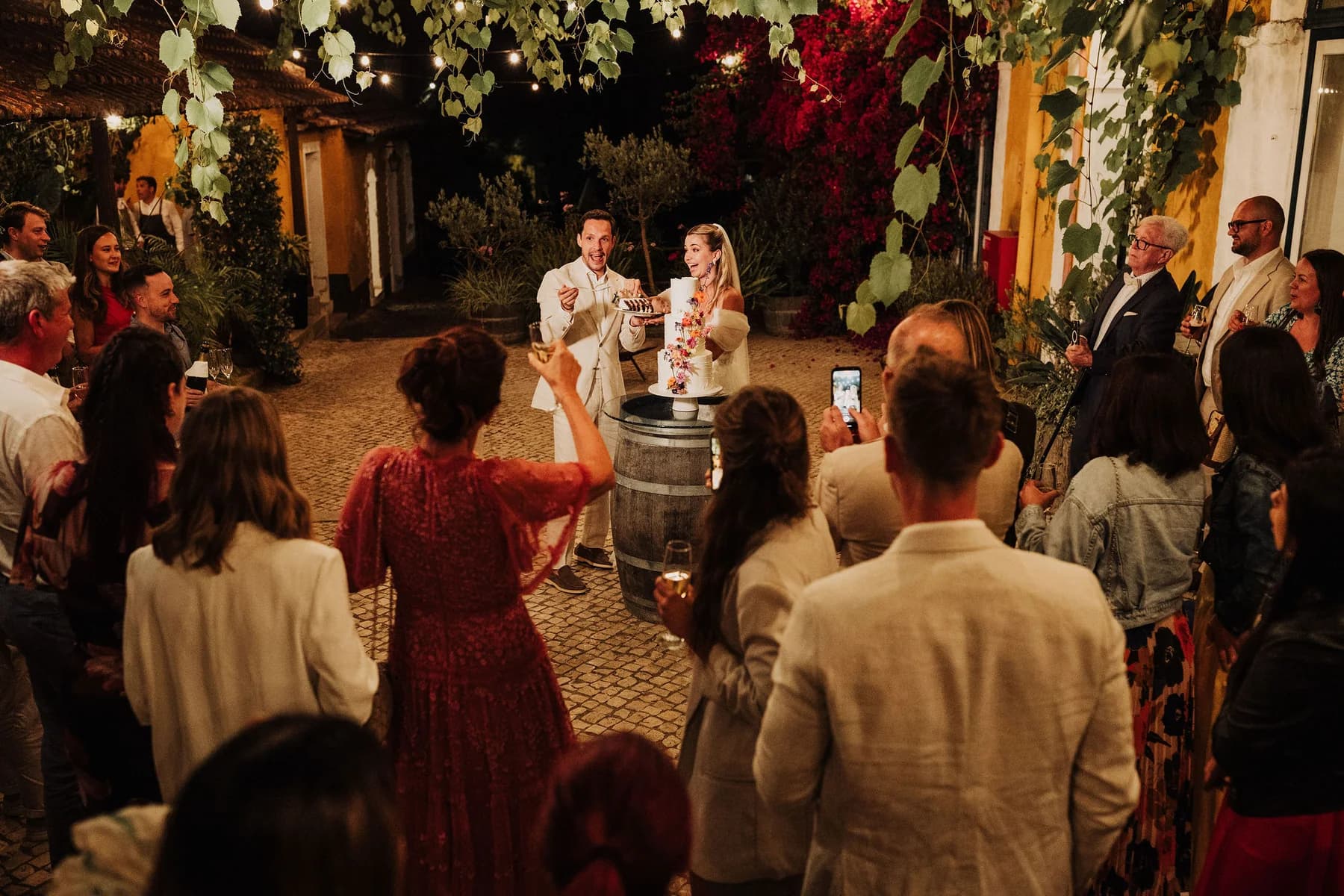 Guests gathered around the couple in the courtyard at night