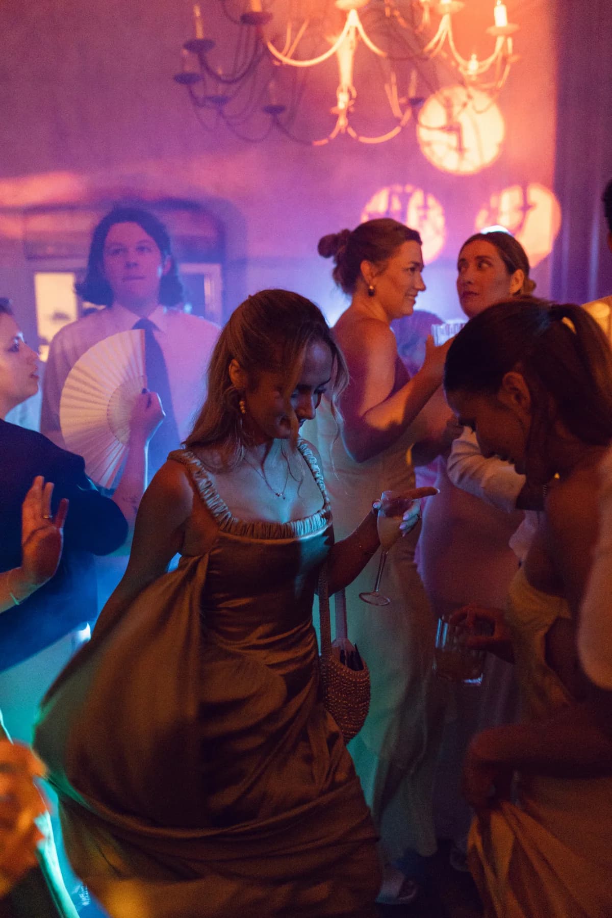 Guests dancing under colourful party lights