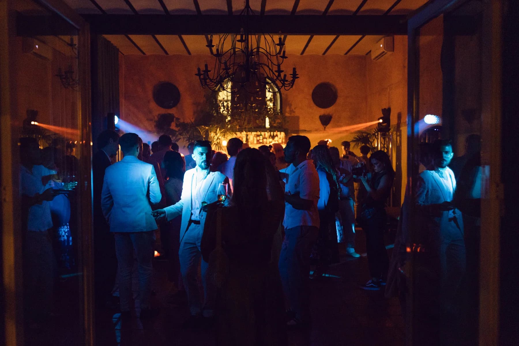 Wedding guests dancing beneath a chandelier
