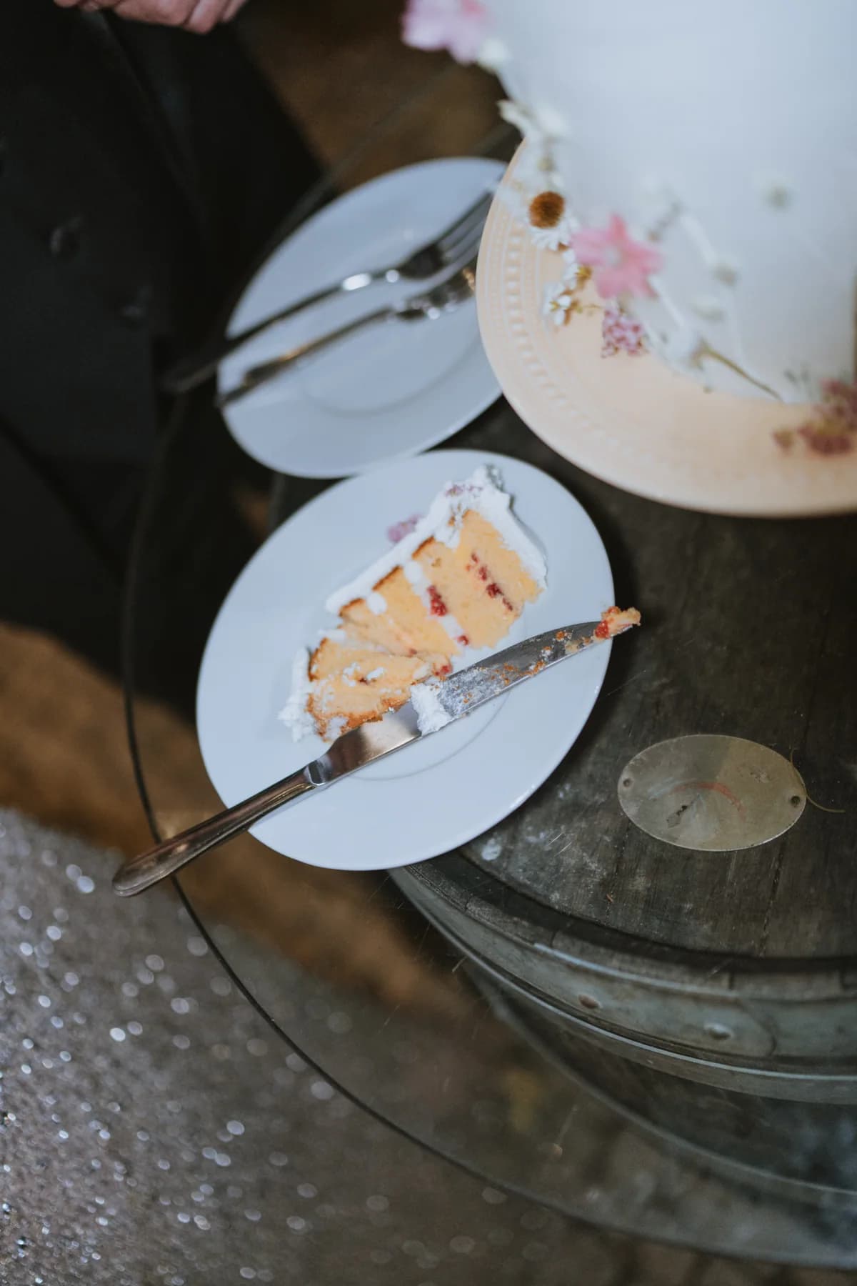 Slices being served from a floral wedding cake