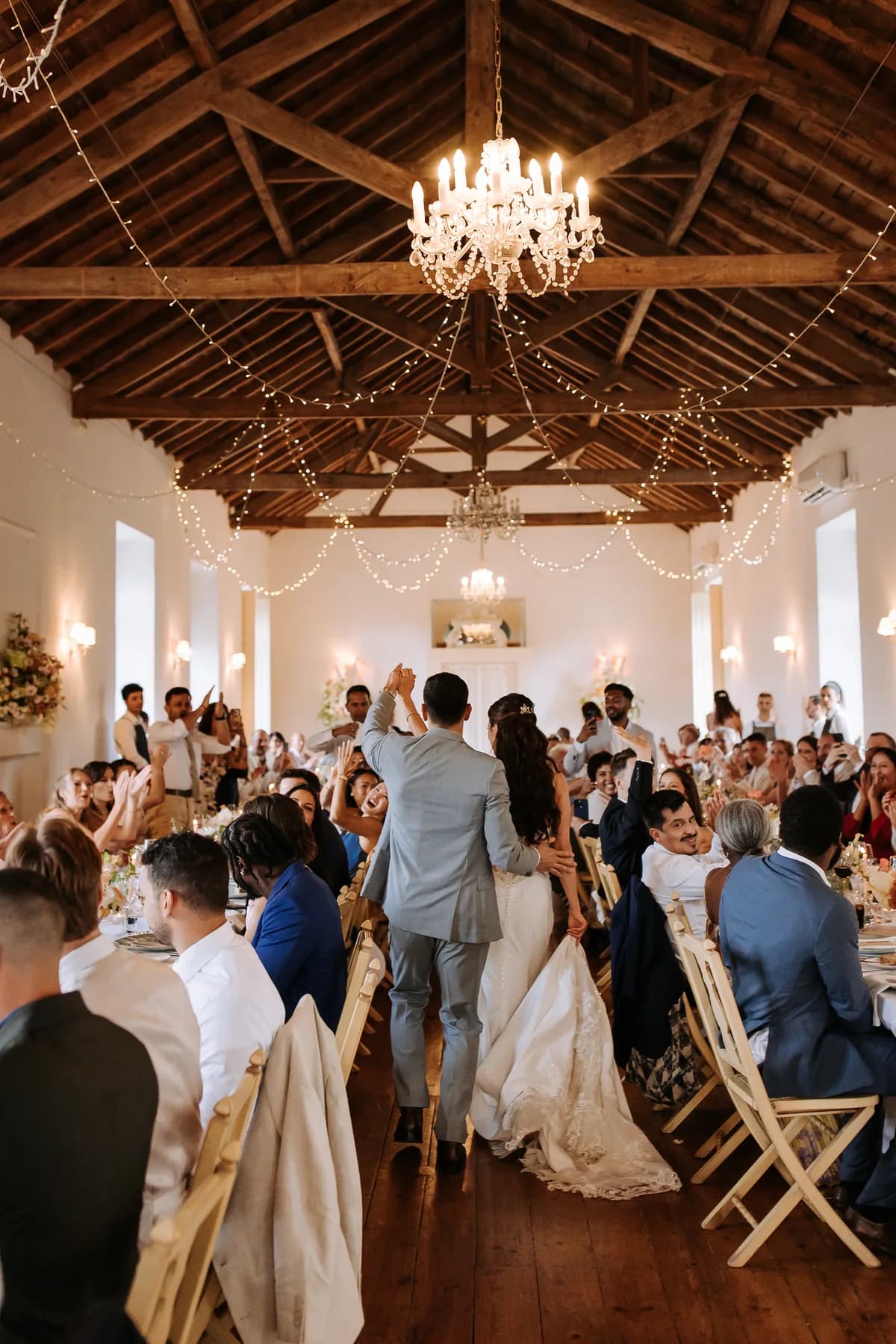 Newlyweds entering a dining hall filled with guests