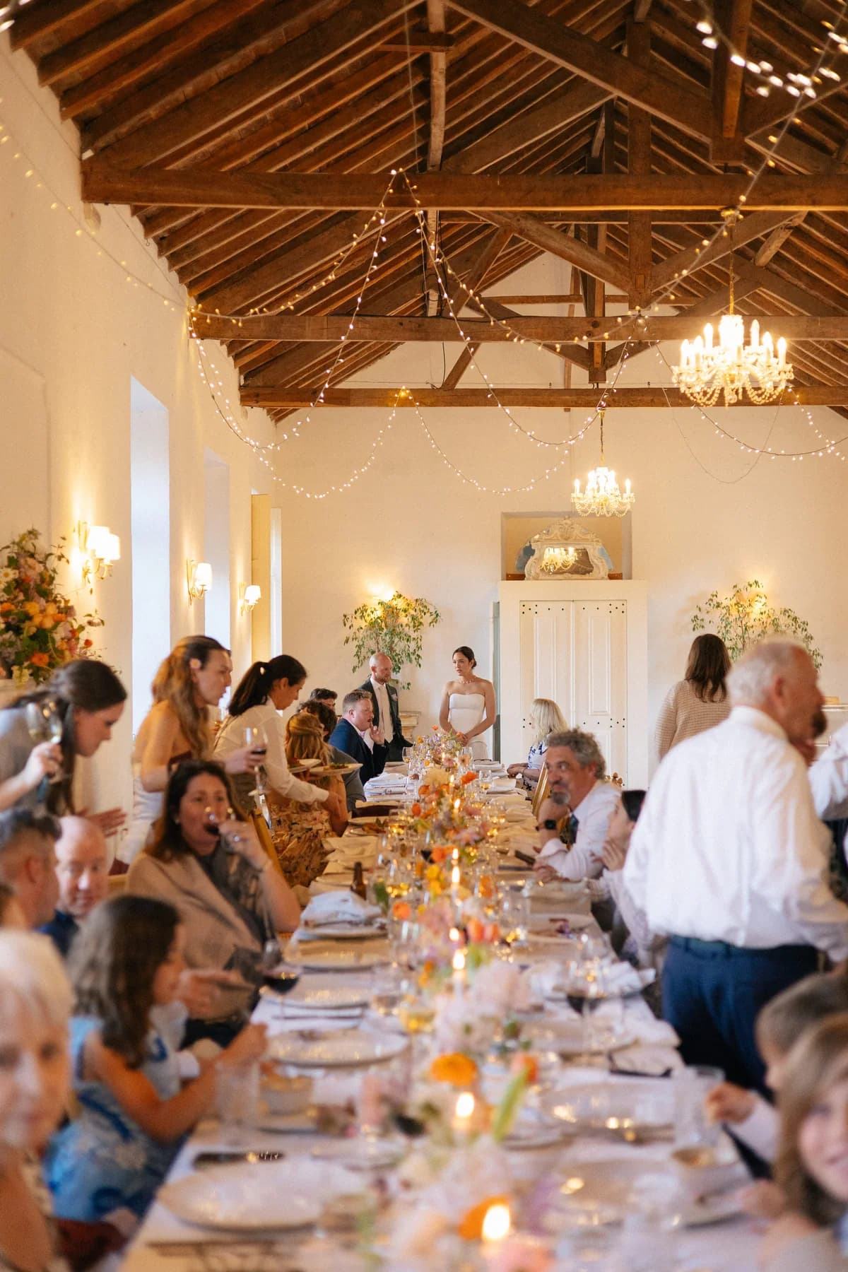 Guests raising their glasses at long reception tables