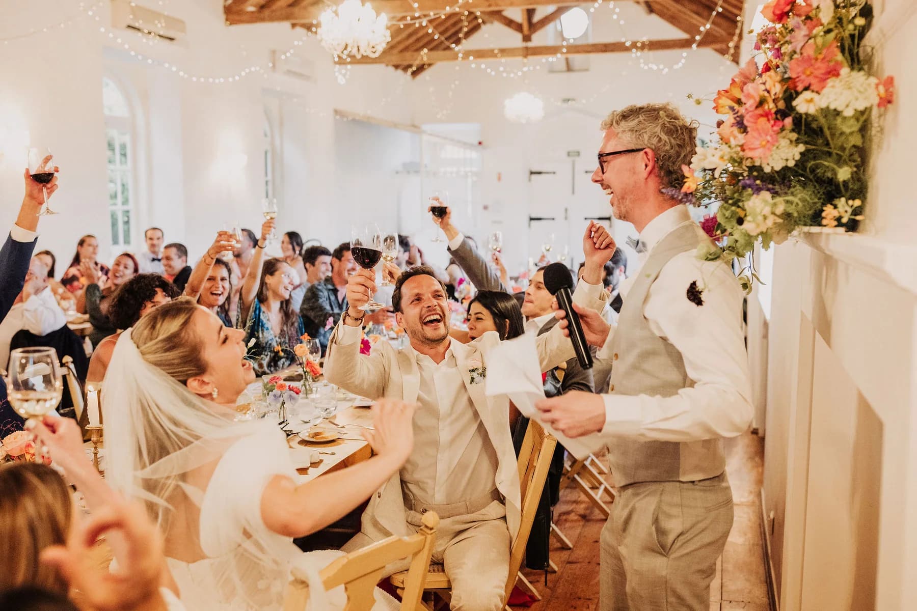 A wedding speech with guests cheering around the table