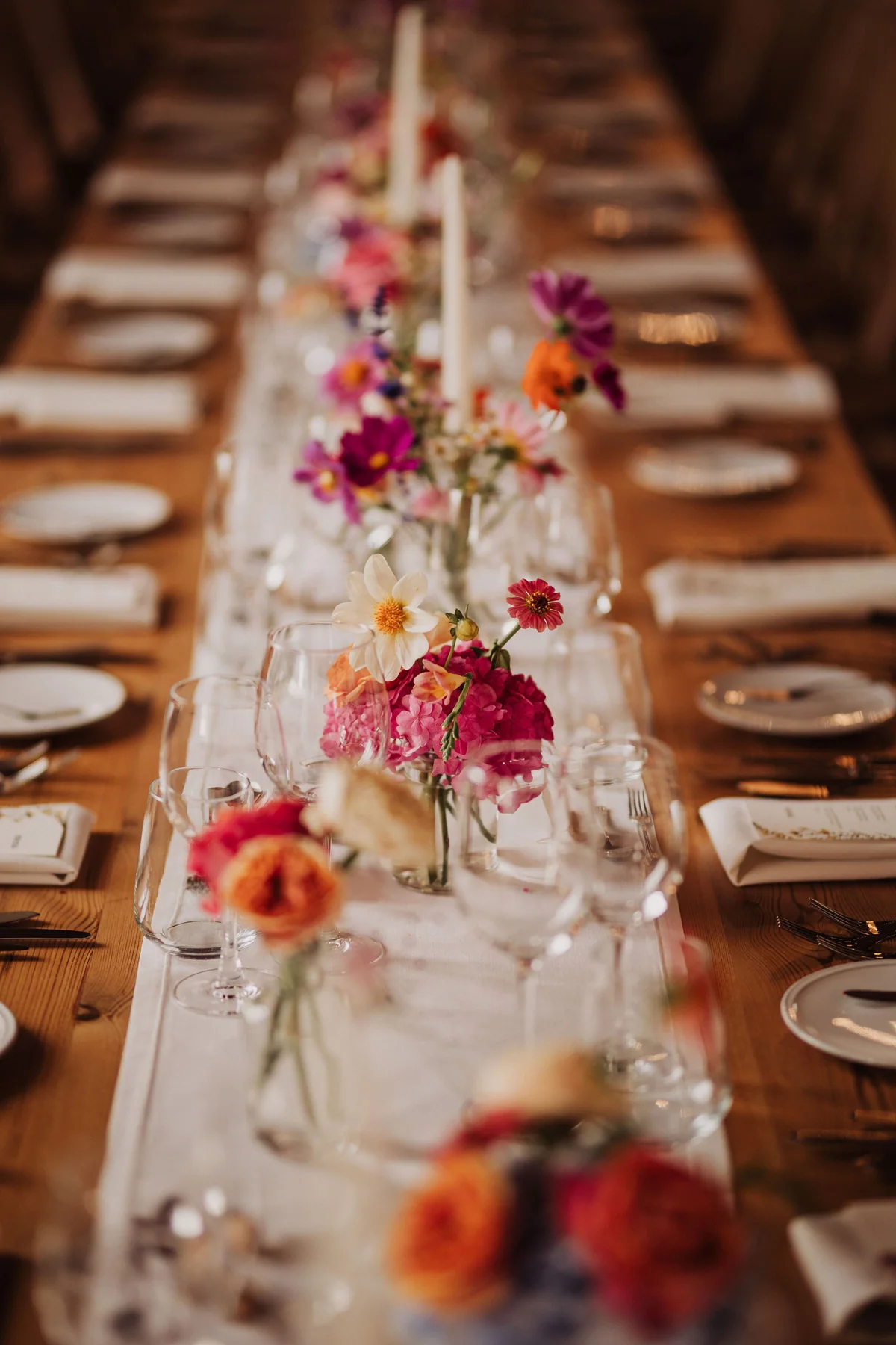 A long reception table decorated with colourful flowers