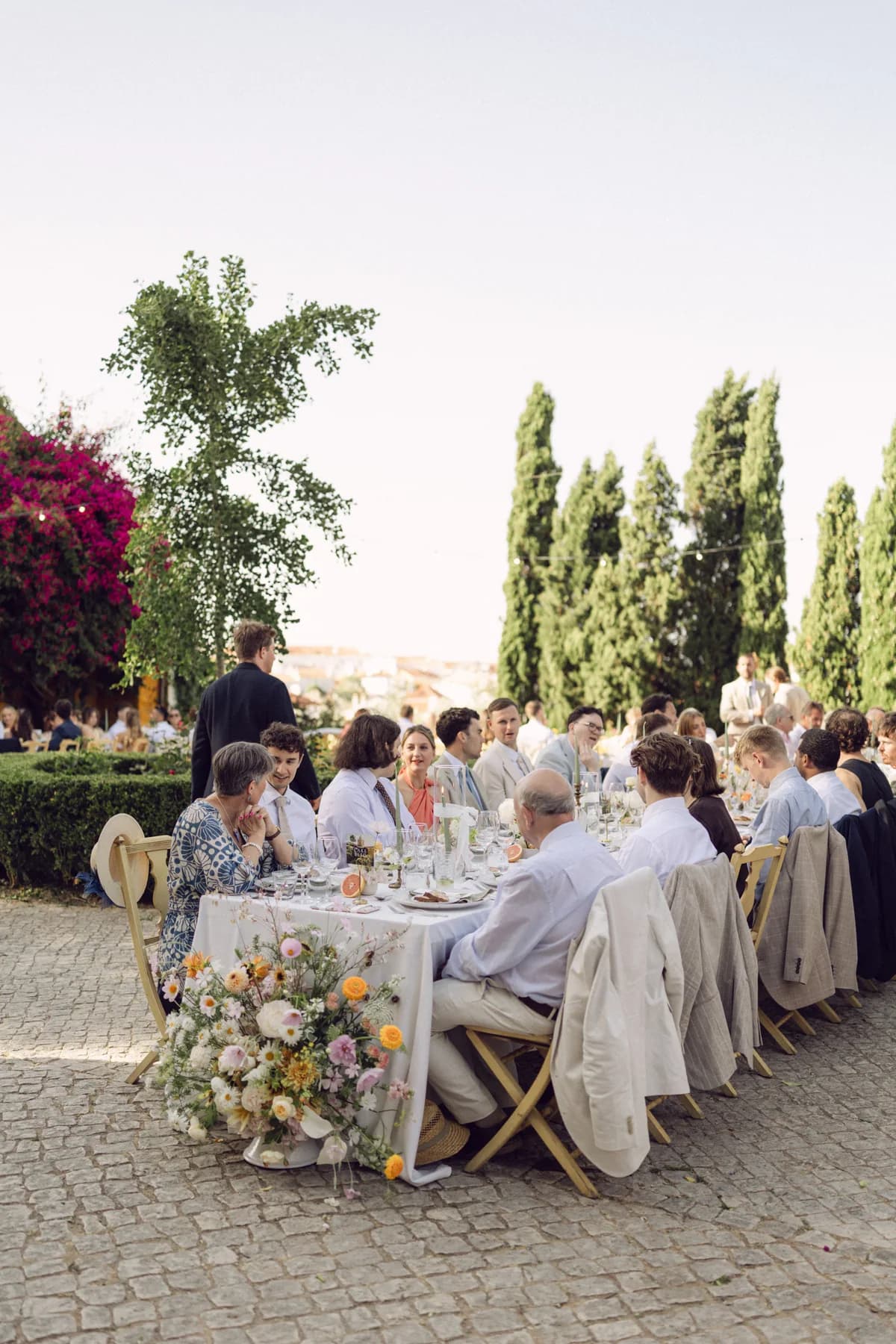 Wedding guests dining at long tables in the courtyard
