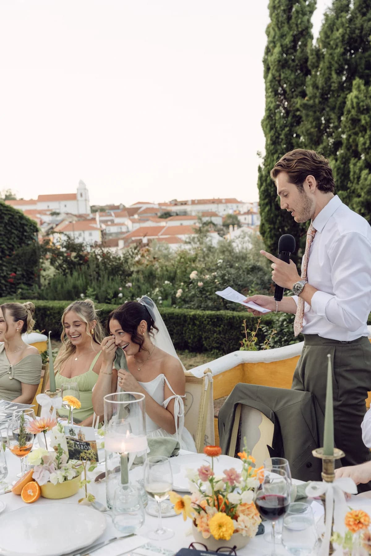 A guest delivering a speech beside an outdoor reception table