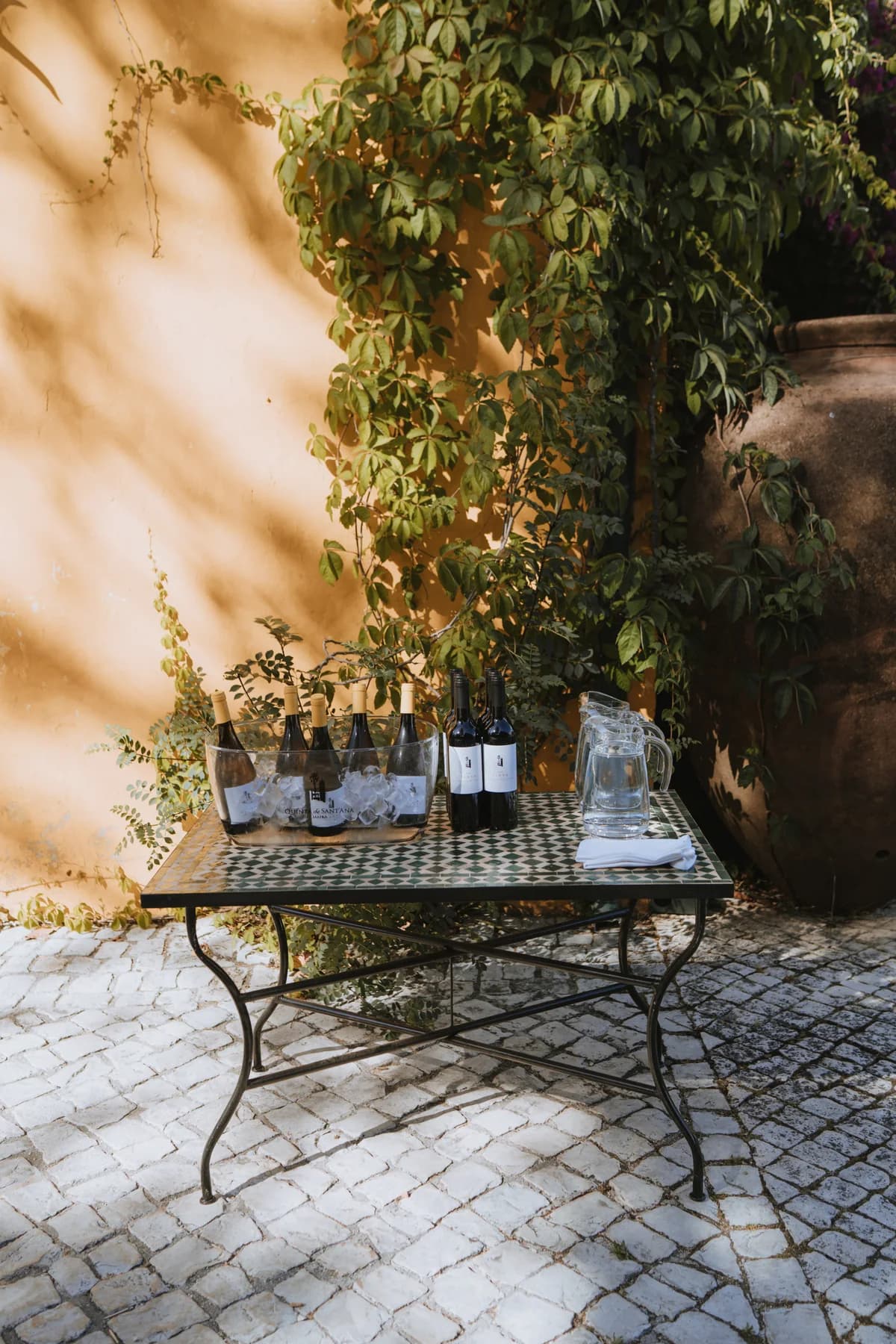A small outdoor table set with drinks and glassware