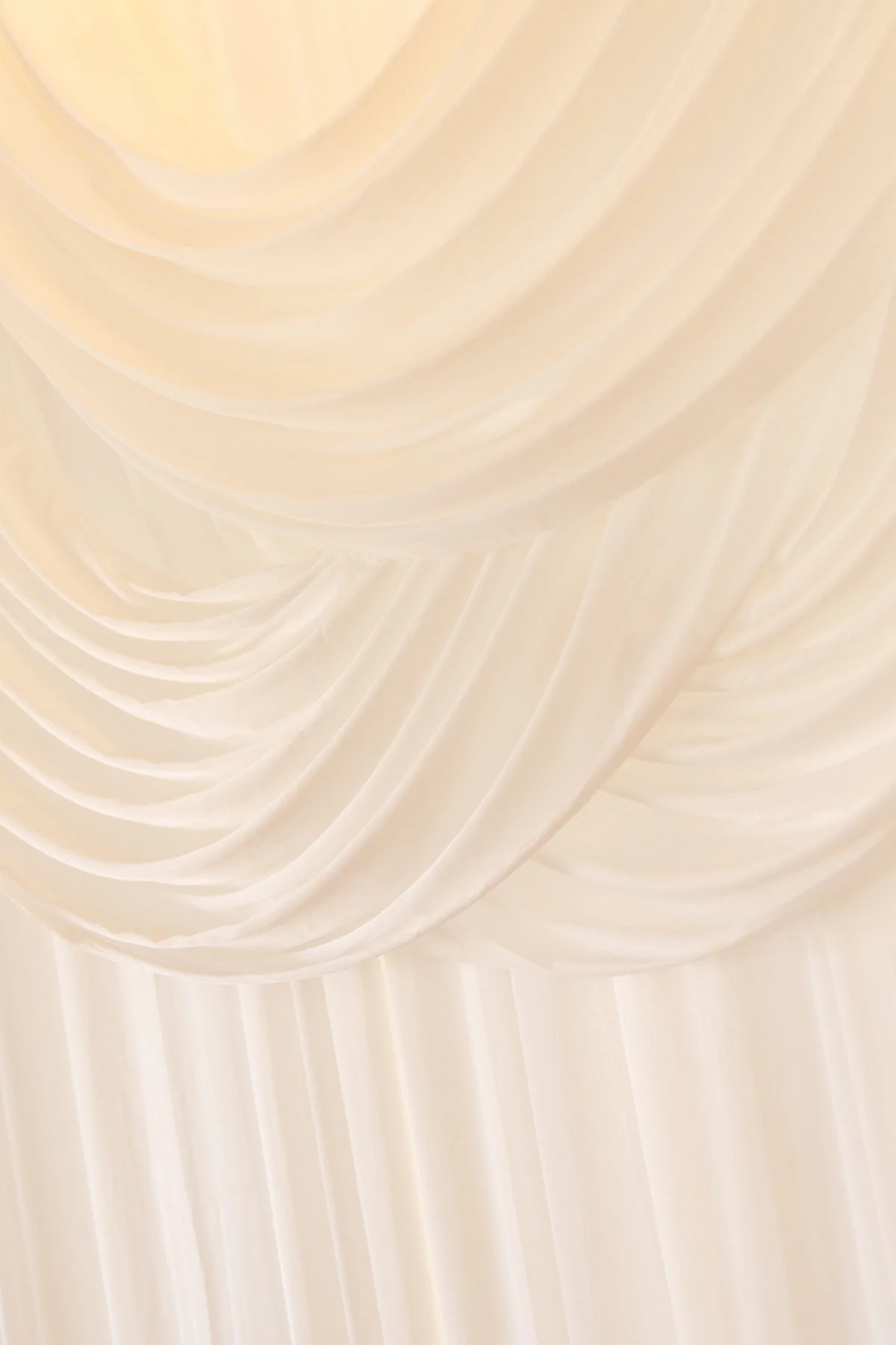 Soft white fabric draped across a reception ceiling