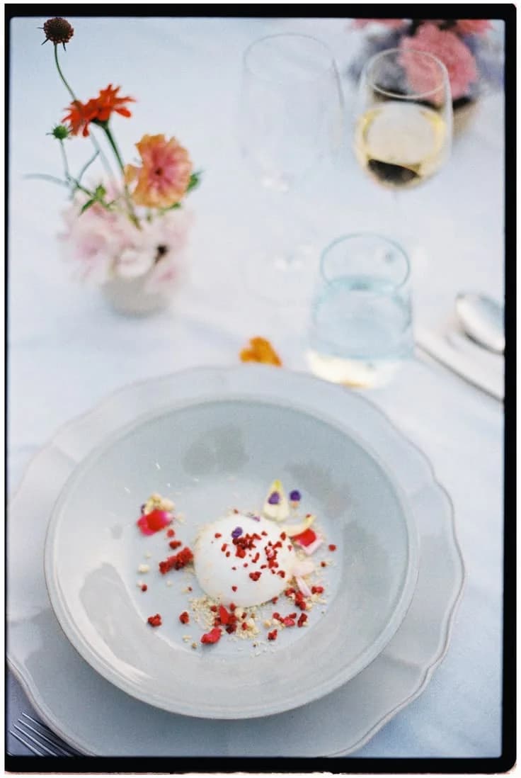 A plated dessert decorated with red petals