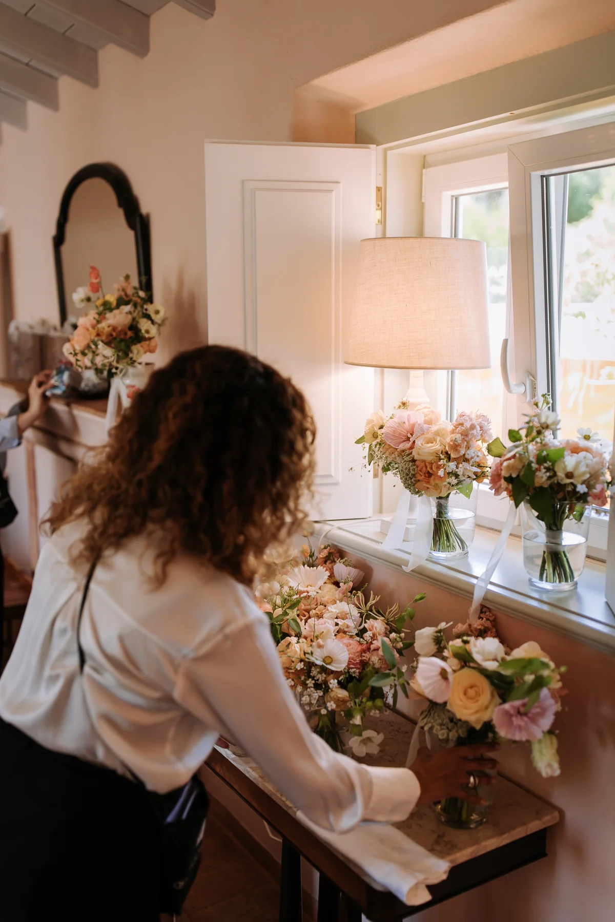 Wedding flowers being prepared beside a dressing table