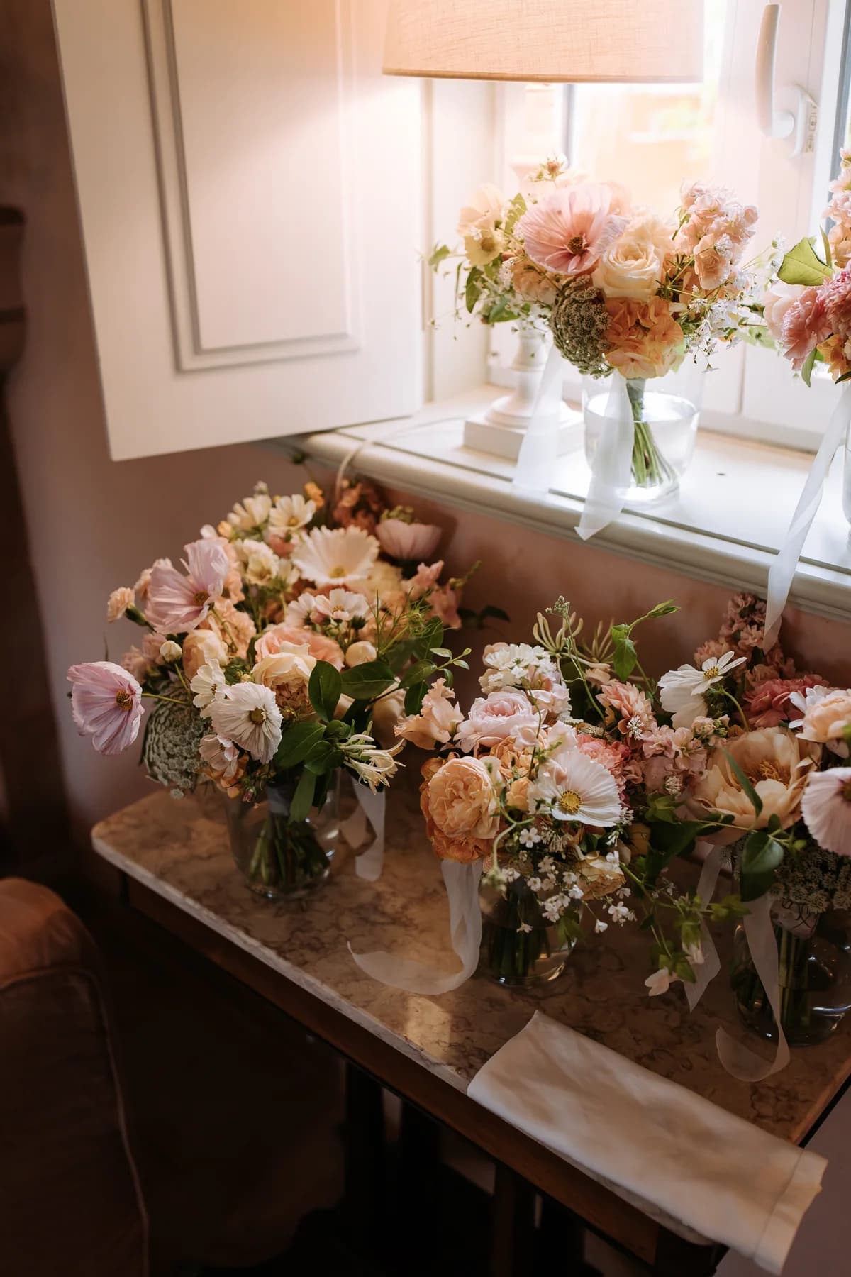 Bridal bouquets arranged on a table beneath a window