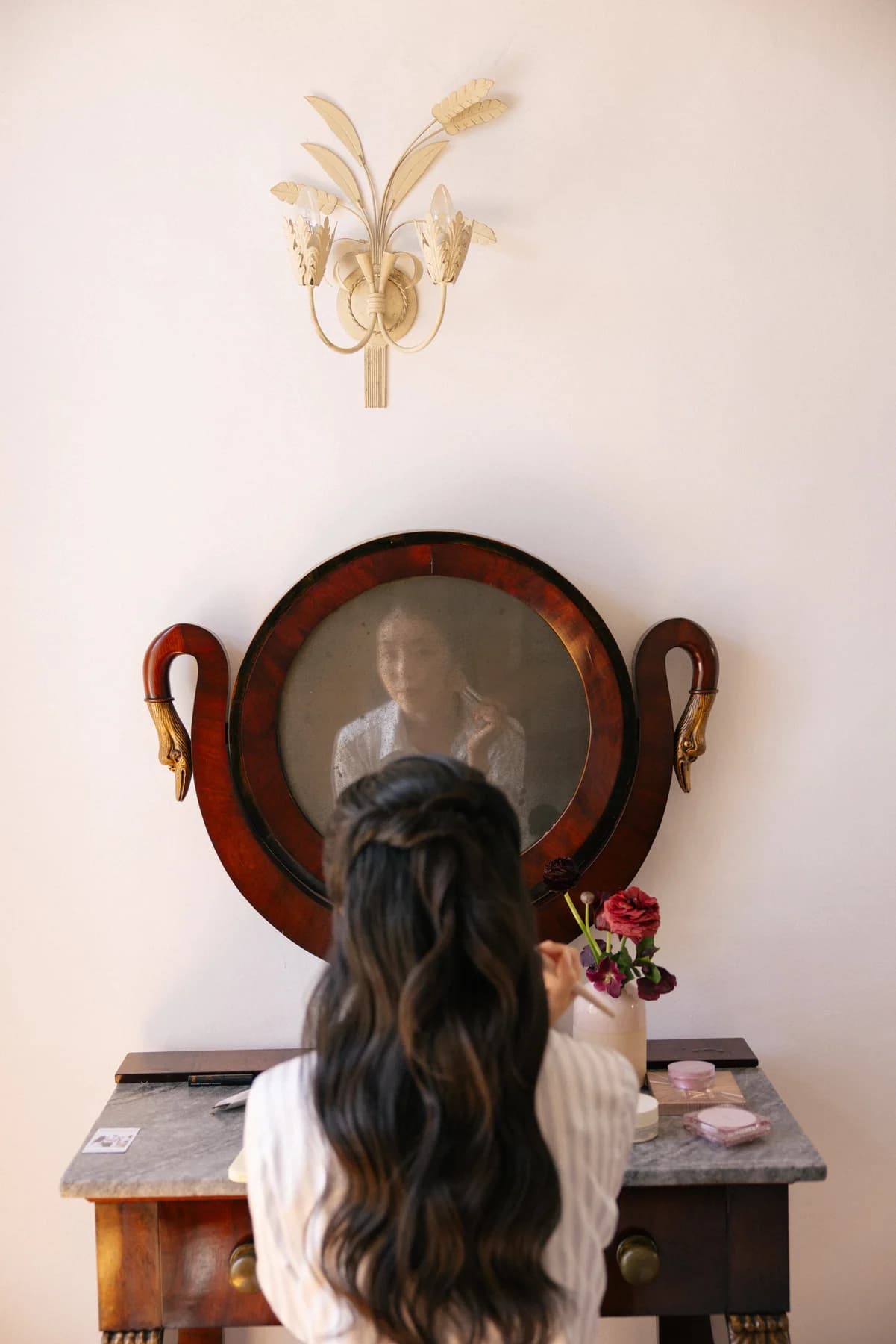 A bride sitting at a dressing table mirror