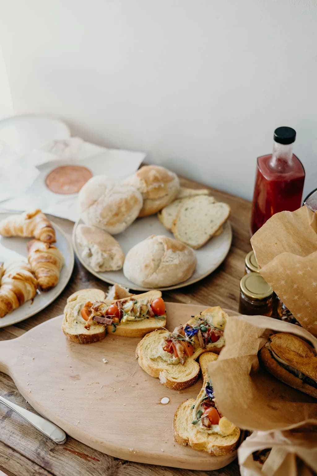 Breakfast breads, pastries and preserves laid out on a wooden table
