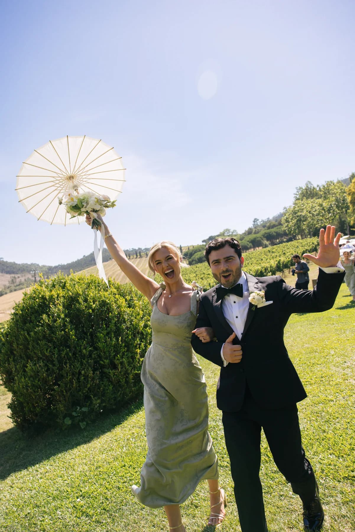 Wedding guests celebrating on the lawn with a white parasol