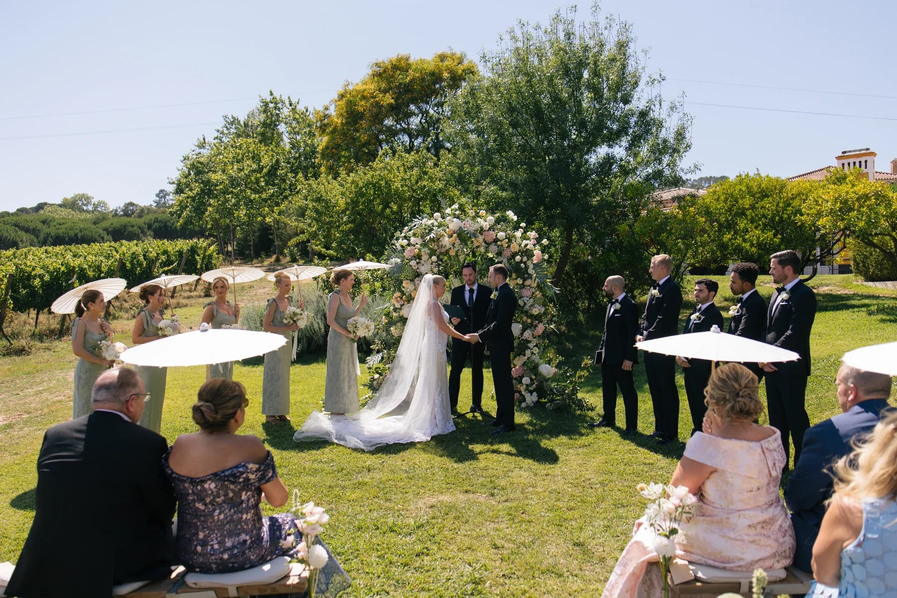 A couple exchanging vows beneath a floral garden arch