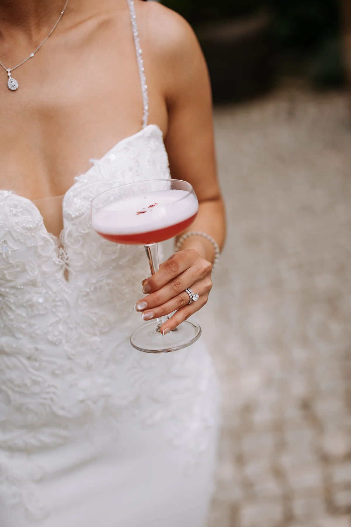 A bride holding a pink cocktail