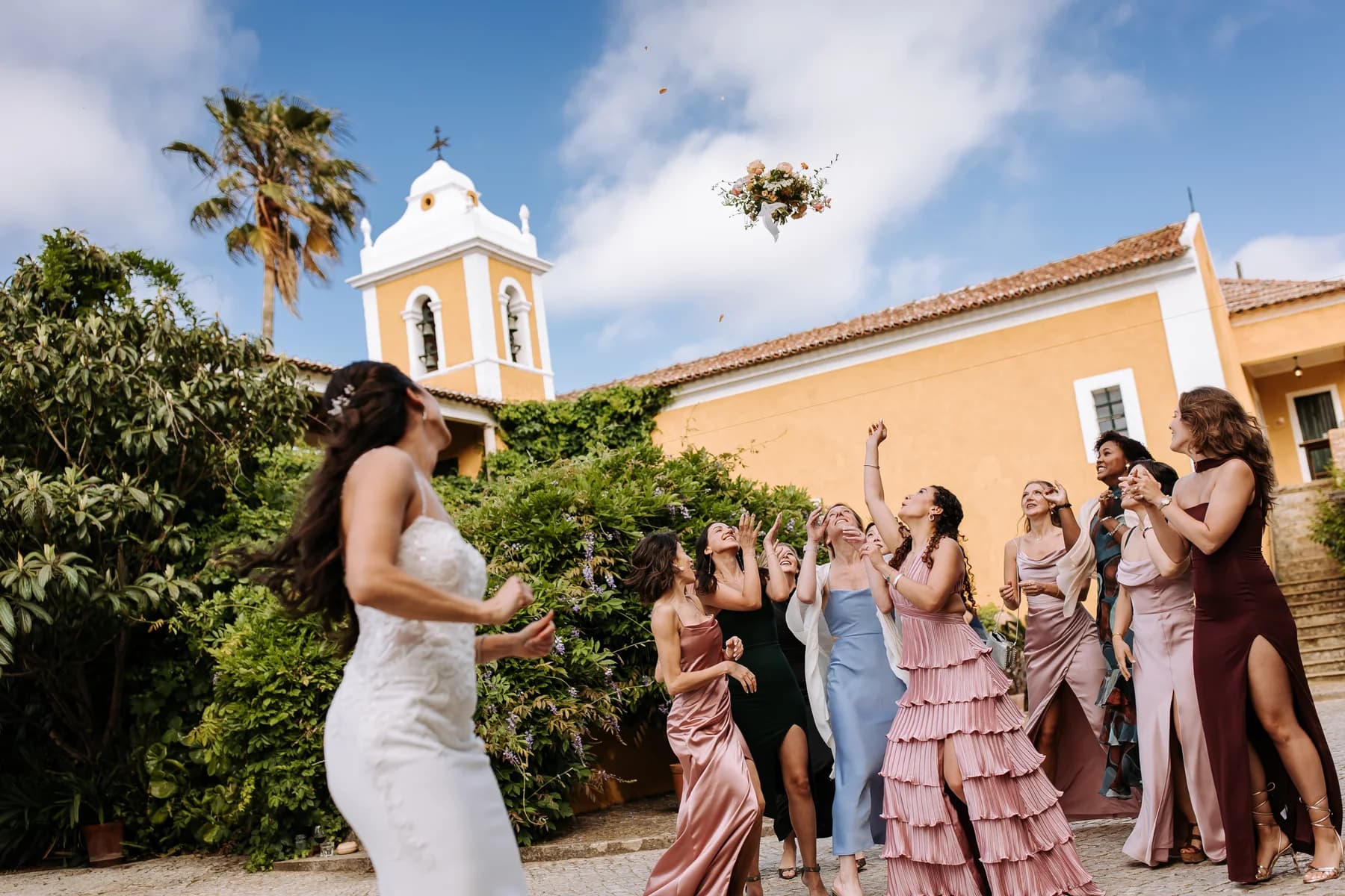 A bride tossing her bouquet in the courtyard