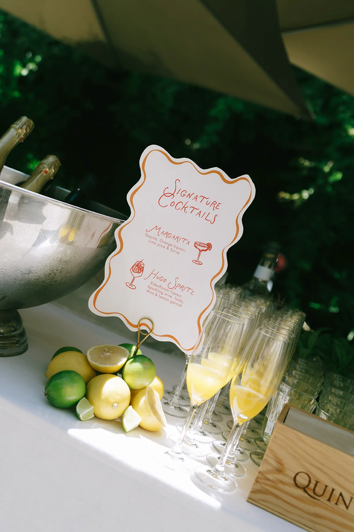 A drinks menu displayed beside limes and cocktail glasses