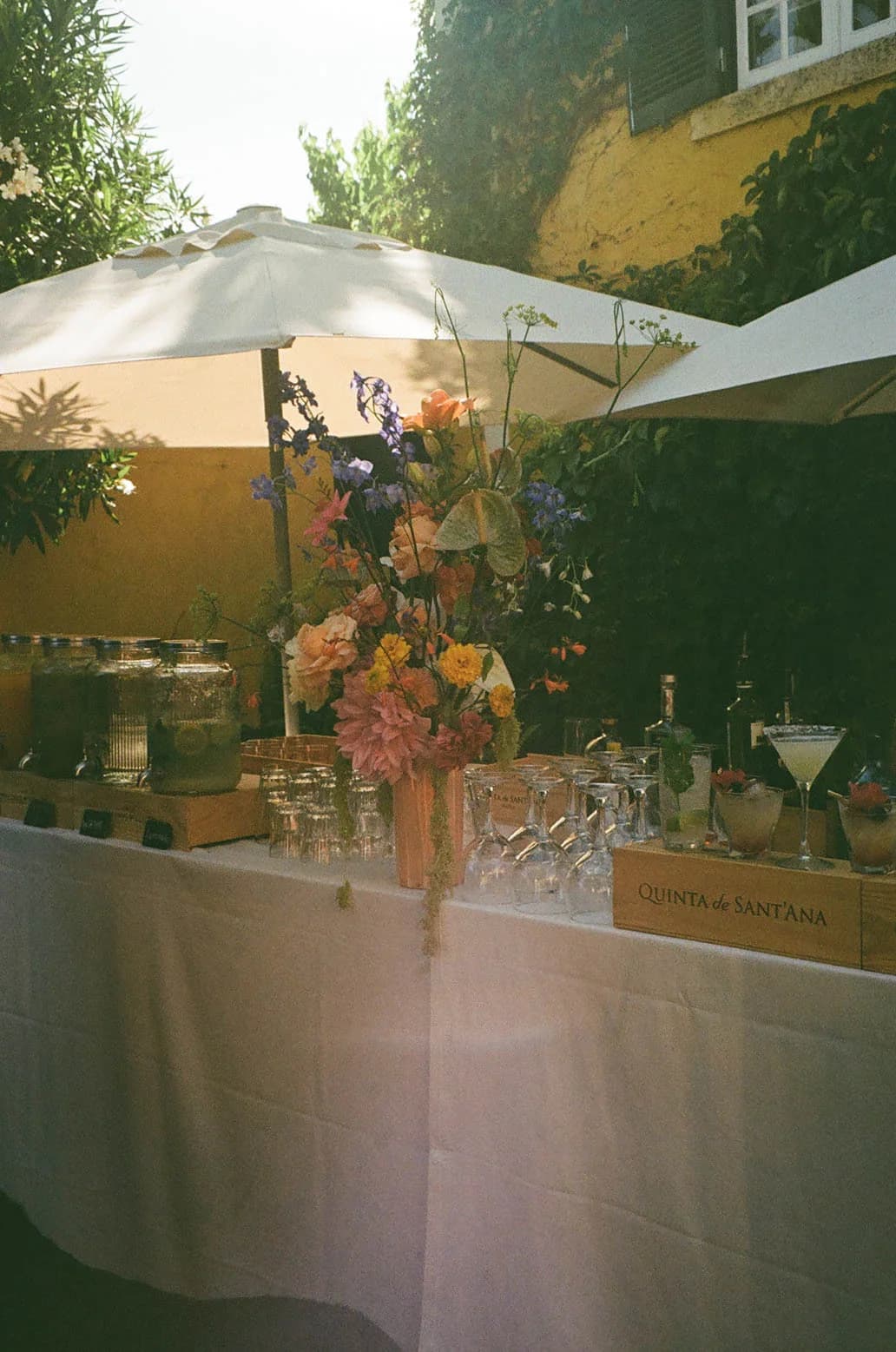 An outdoor drinks table beneath a garden parasol