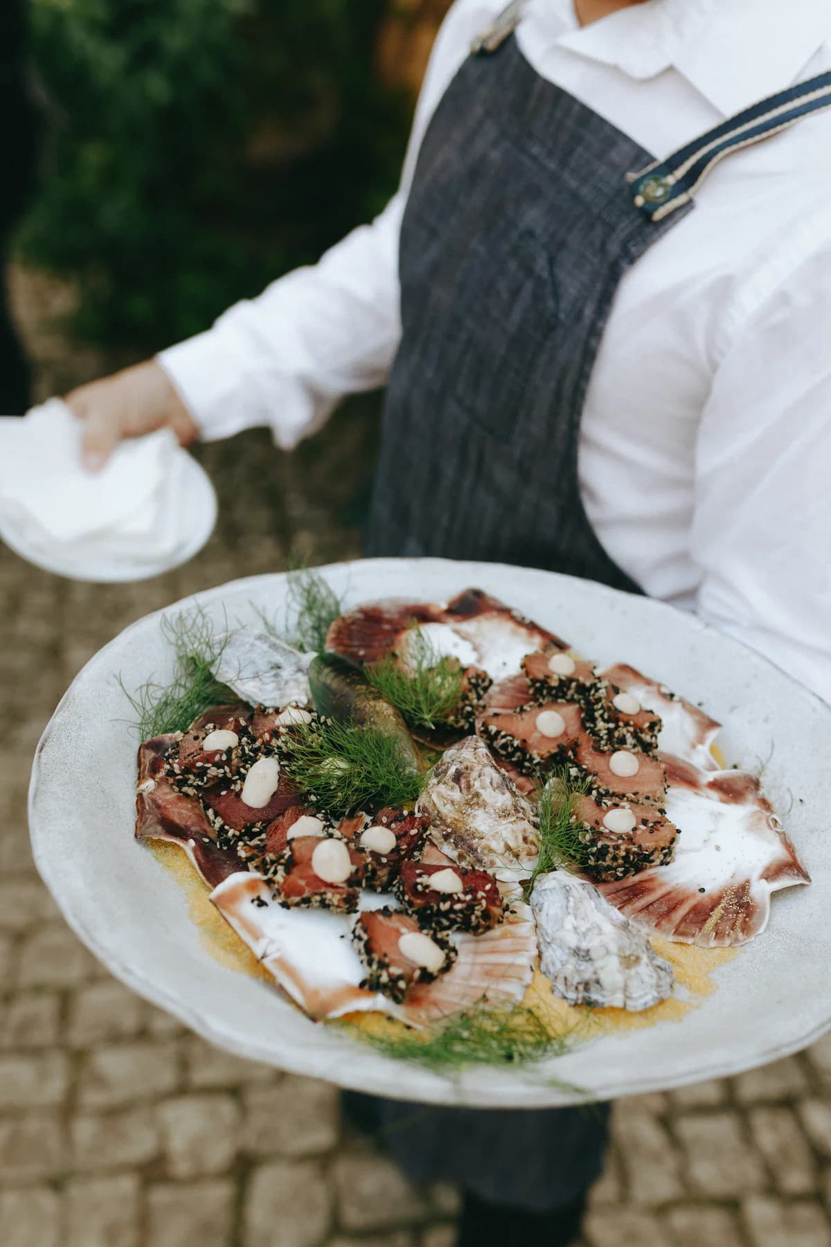 A server carrying a platter of canapés