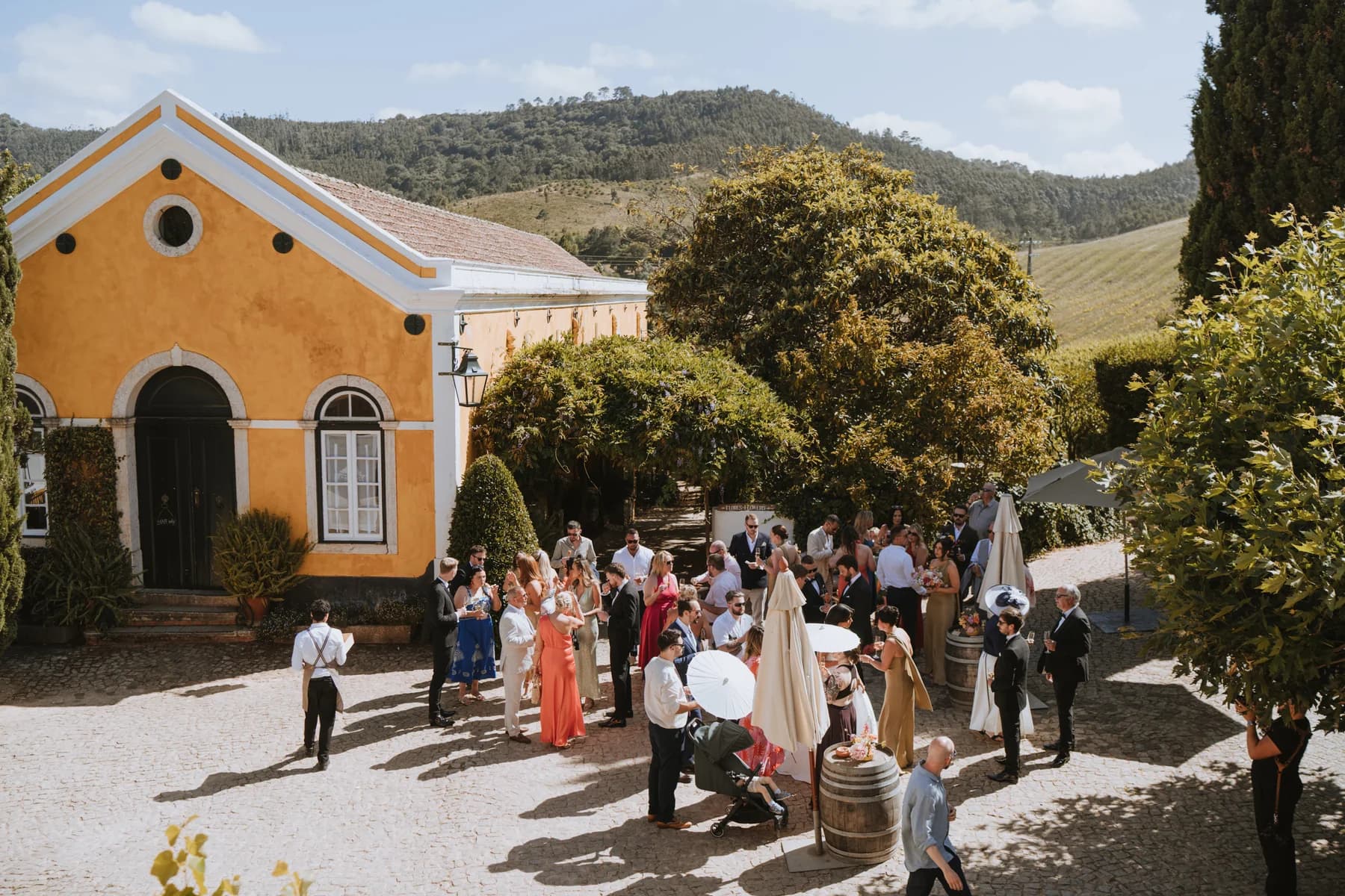 Guests enjoying drinks outside the yellow chapel
