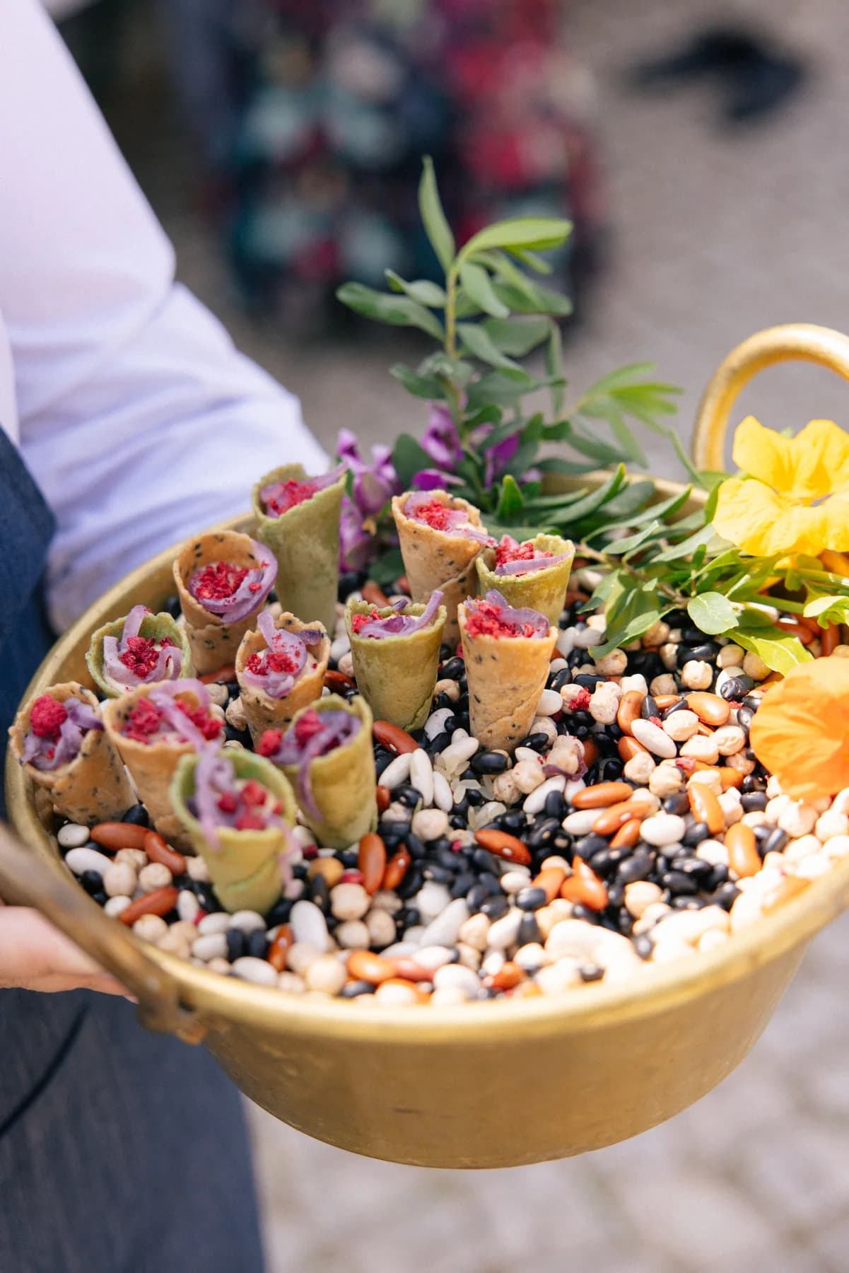 A server presenting a colourful tray of canapés