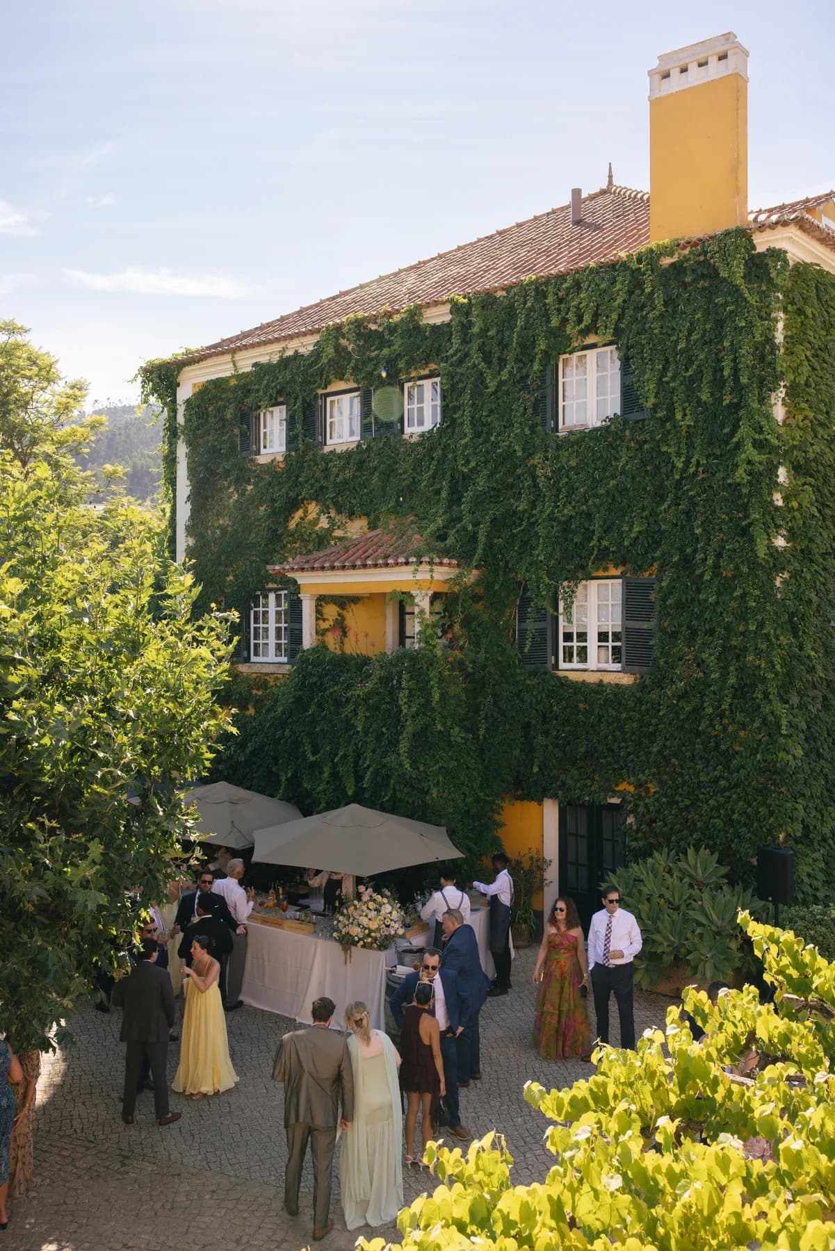 Guests gathering below the ivy-covered main house