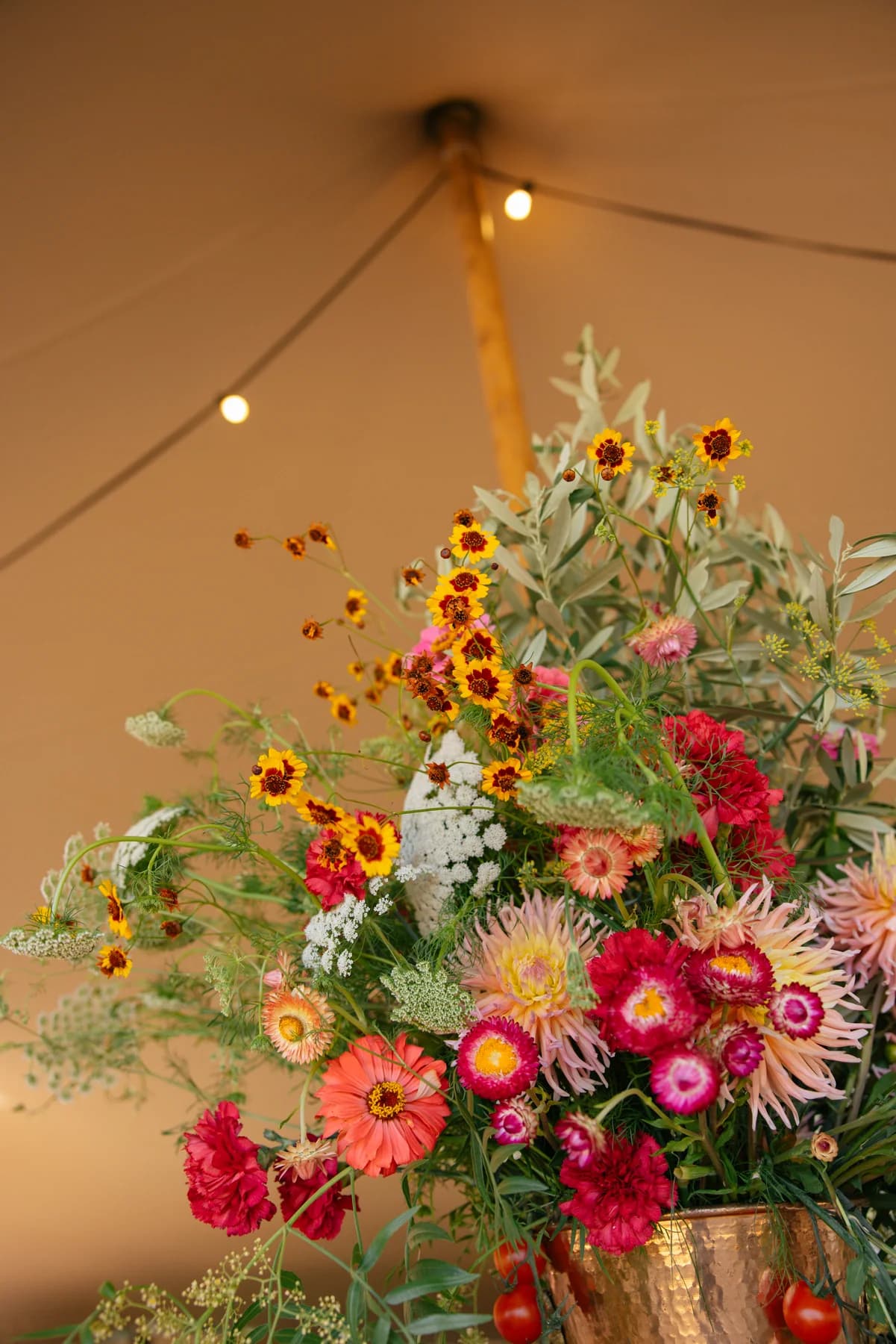 Bright red, pink and yellow flowers inside the welcome tent