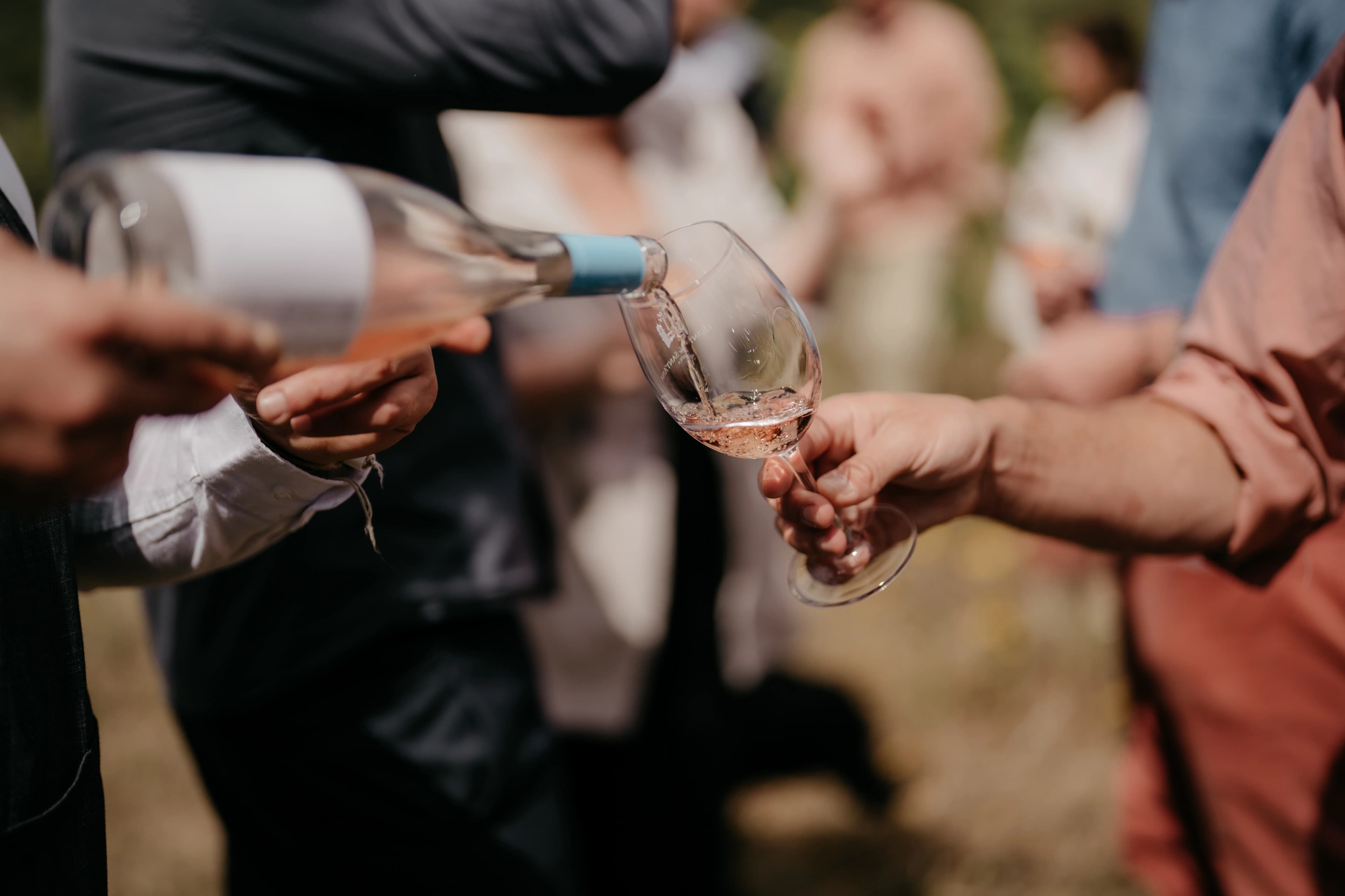 Estate rosé being poured into a Quinta de Sant'Ana wine glass for a guest