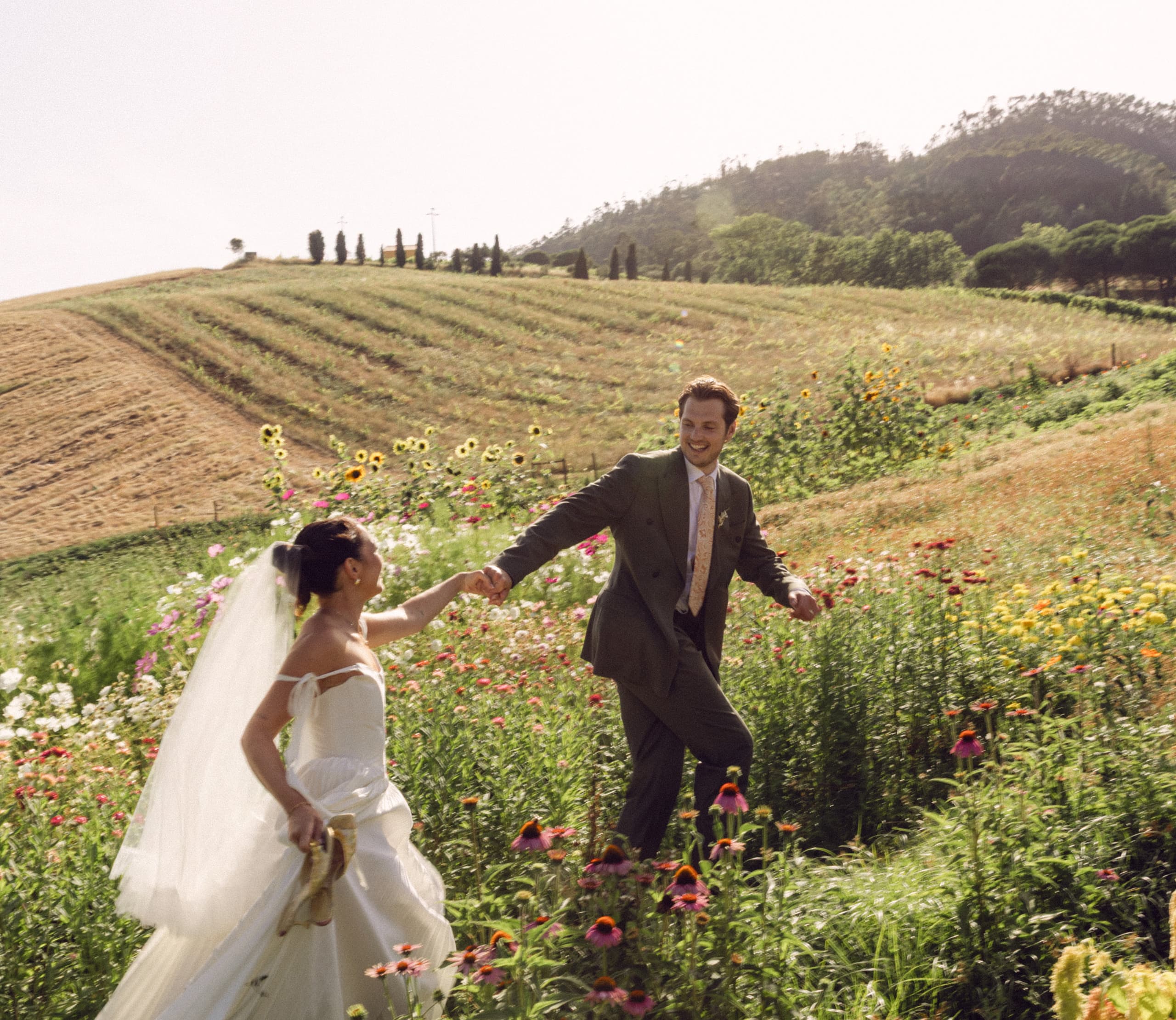 A newly married couple walking together through the Quinta's flower garden