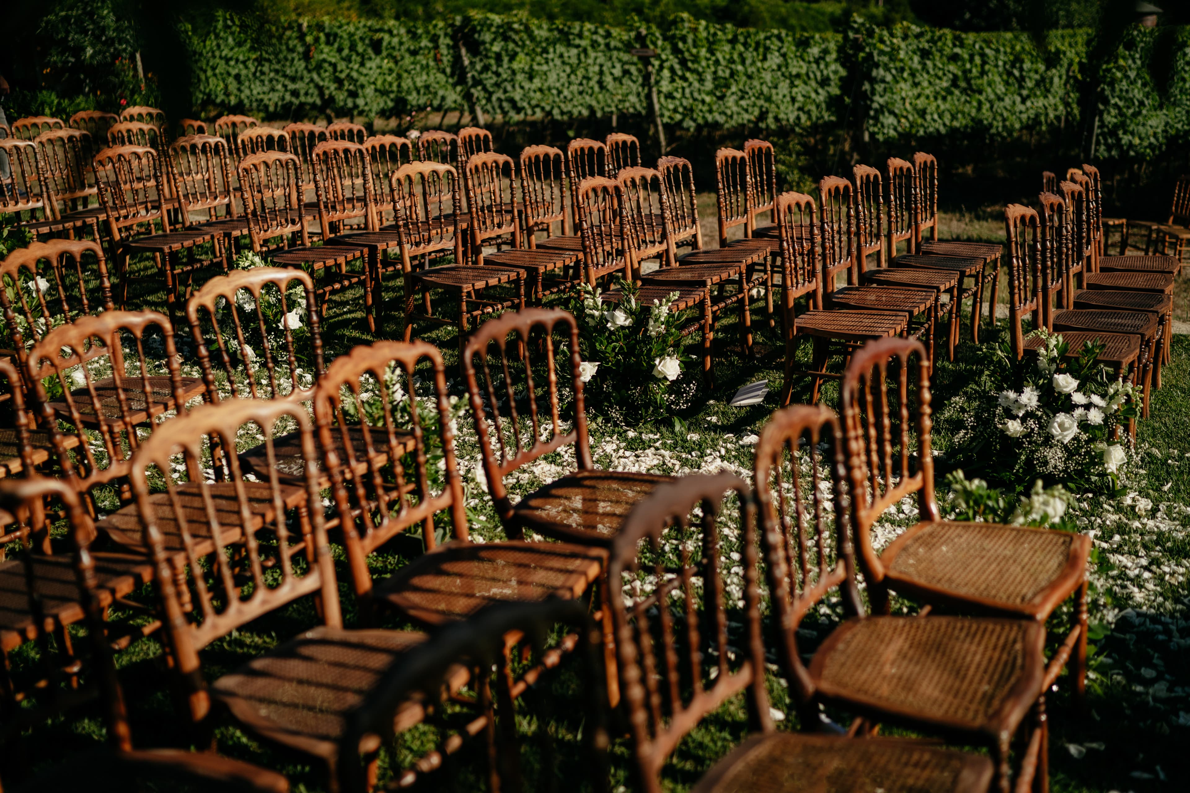 Wooden chairs and flowers laid out for a garden ceremony at the estate