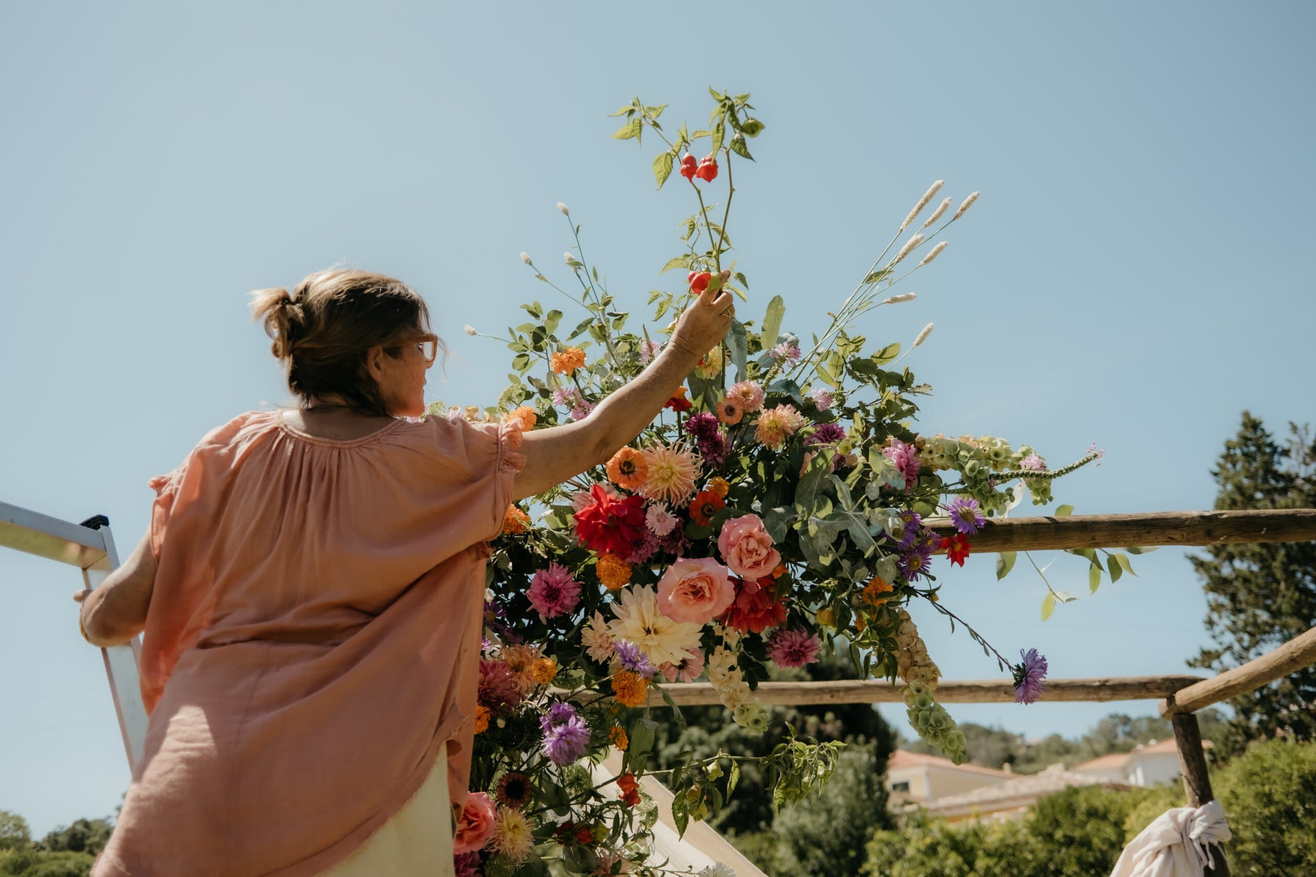 The estate florist building a colourful ceremony arrangement with seasonal flowers