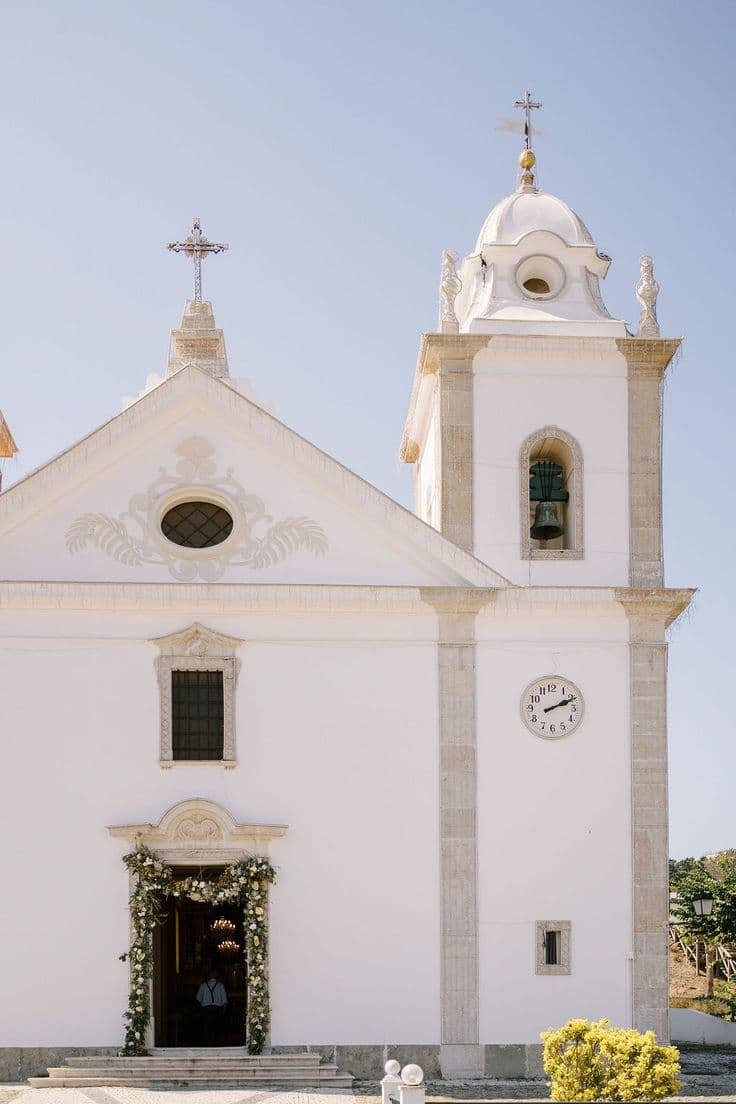 White church facade with floral arch at the entrance