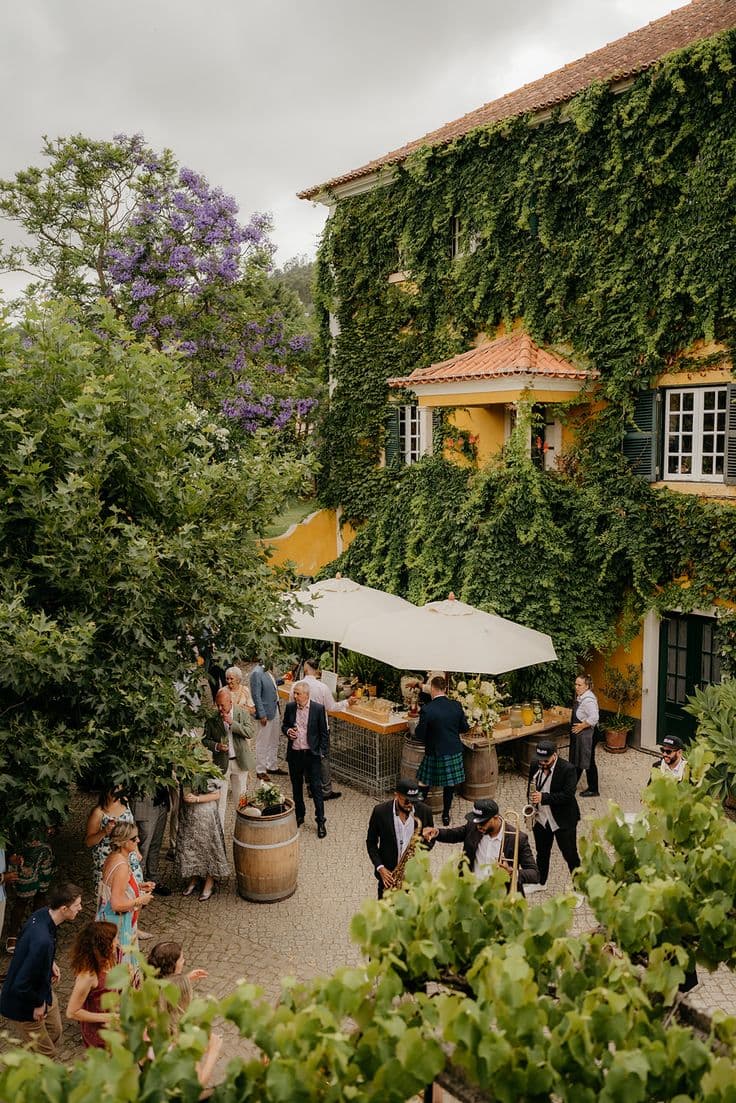 Guests gathering for drinks beside the ivy-covered courtyard buildings