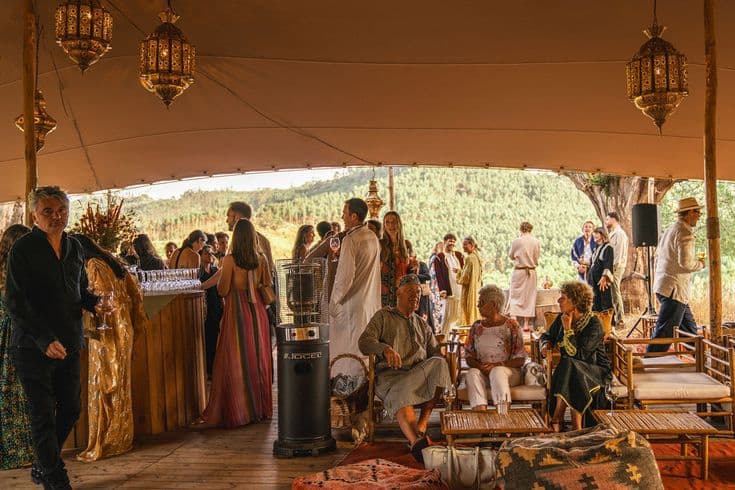 Guests catching up over drinks inside the lantern-lit Pinhal Tent