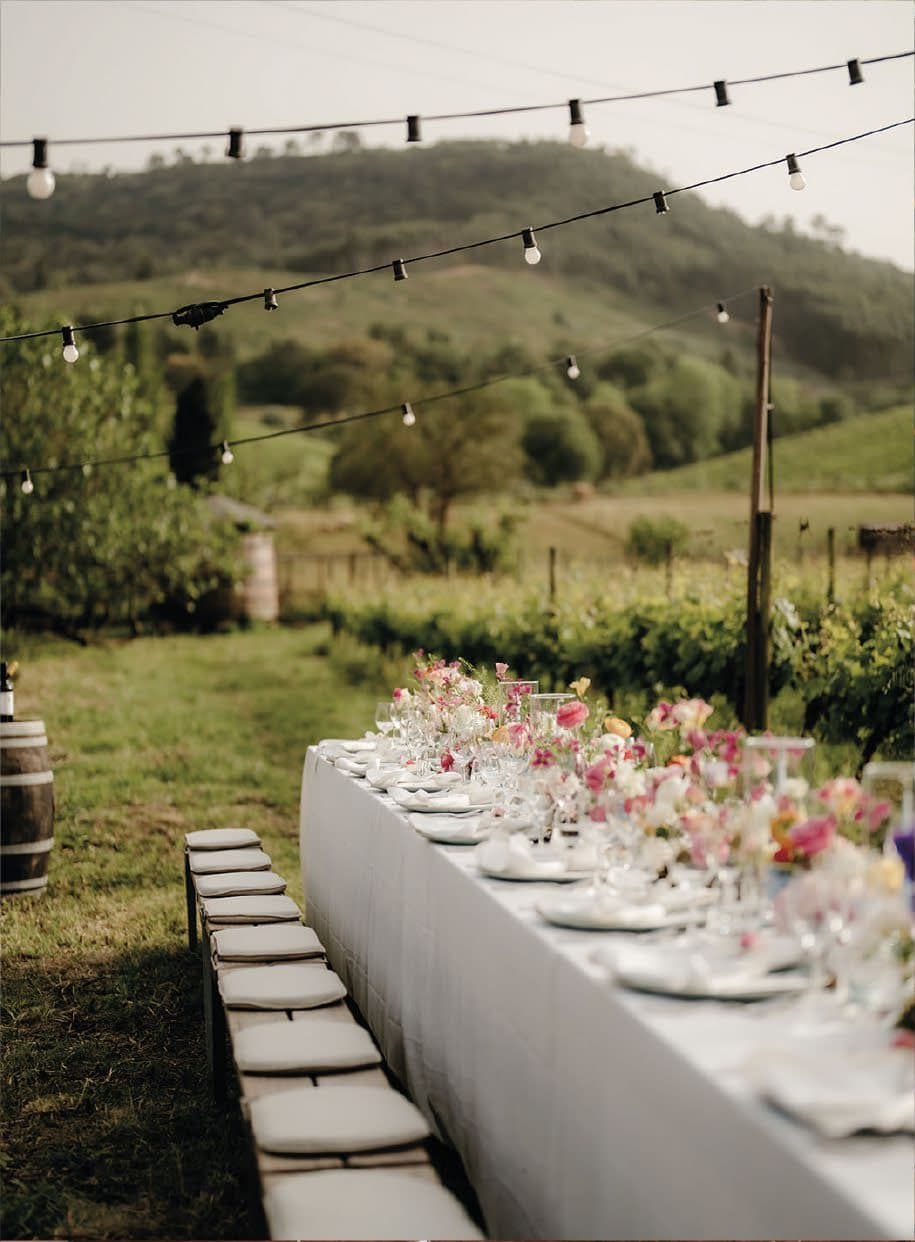 Dinner table at twilight with string lights and hills